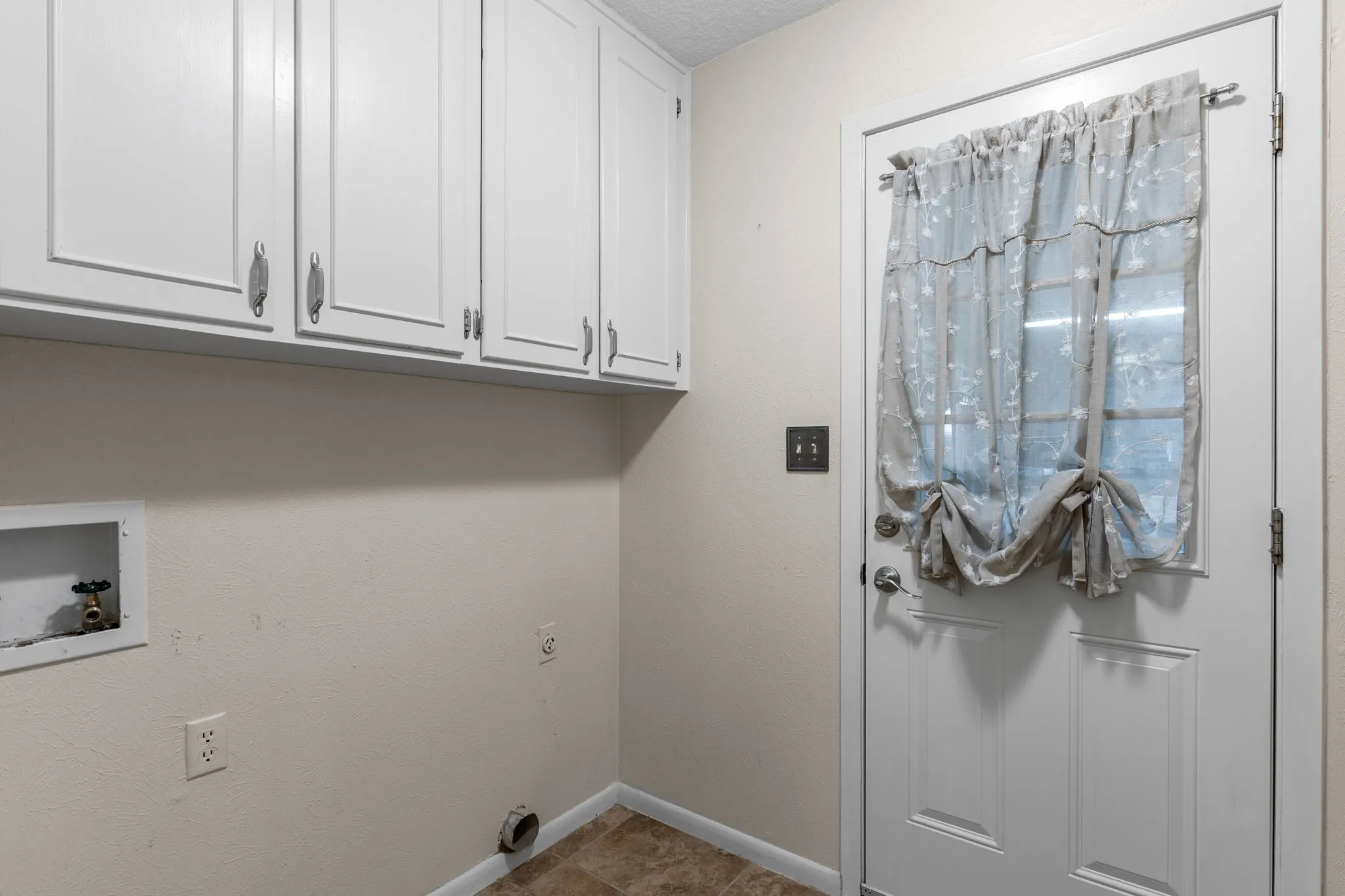 White upper cabinetry with brushed nickel hardware. Full sized washer and dryer hook ups. Entry to the garage.