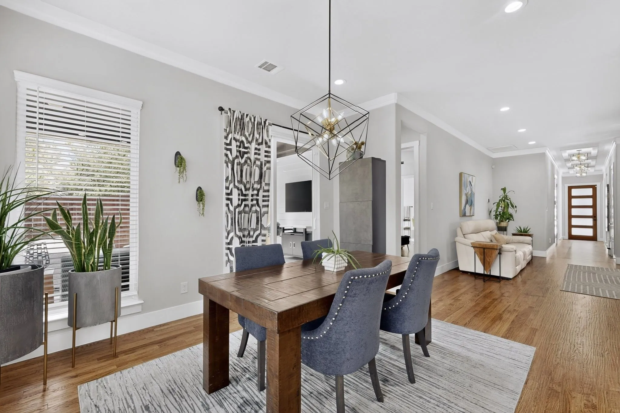 Hardwood flooring, recessed lighting, crown molding, a decorative chandelier, and a wood entry door with frosted glass panels