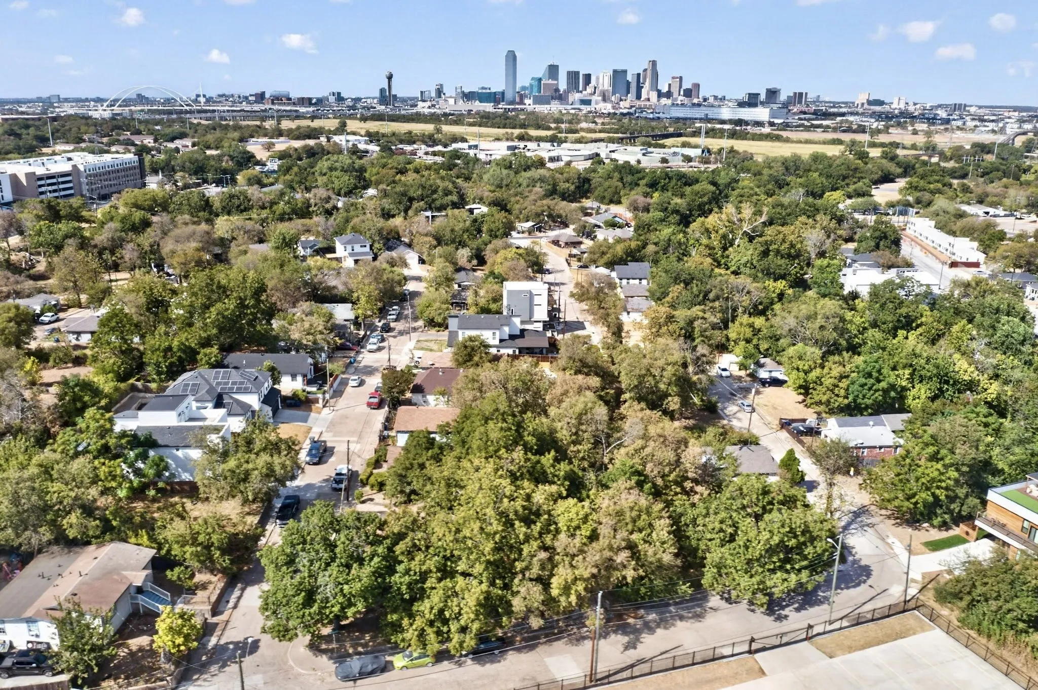 Residential neighborhood with abundant mature trees and a distant cityscape
