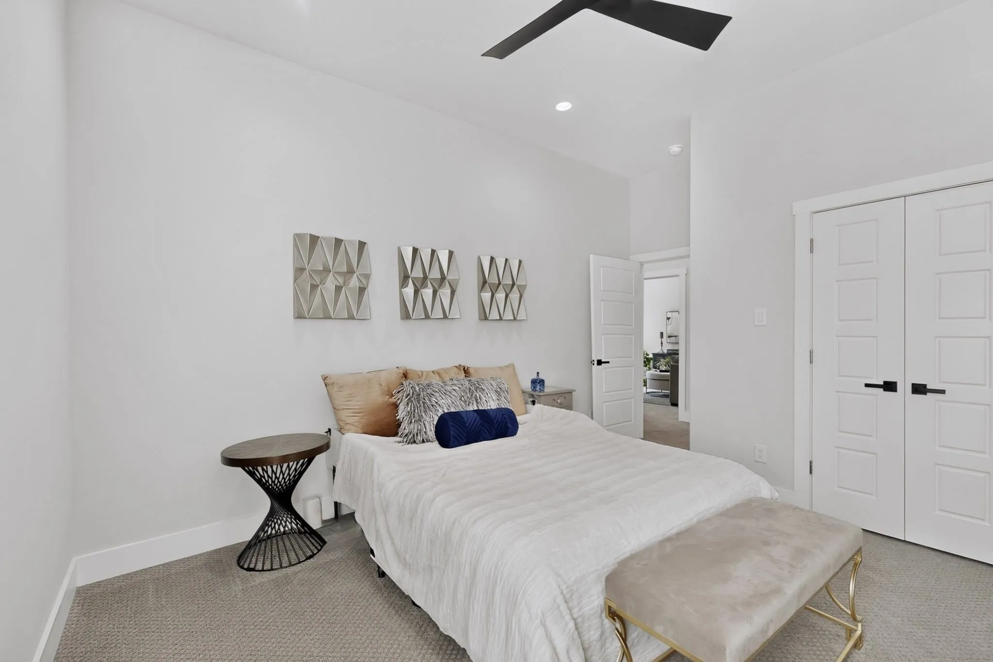 Recessed lighting, ceiling fan, white paneled doors with black hardware, and gray carpet flooring