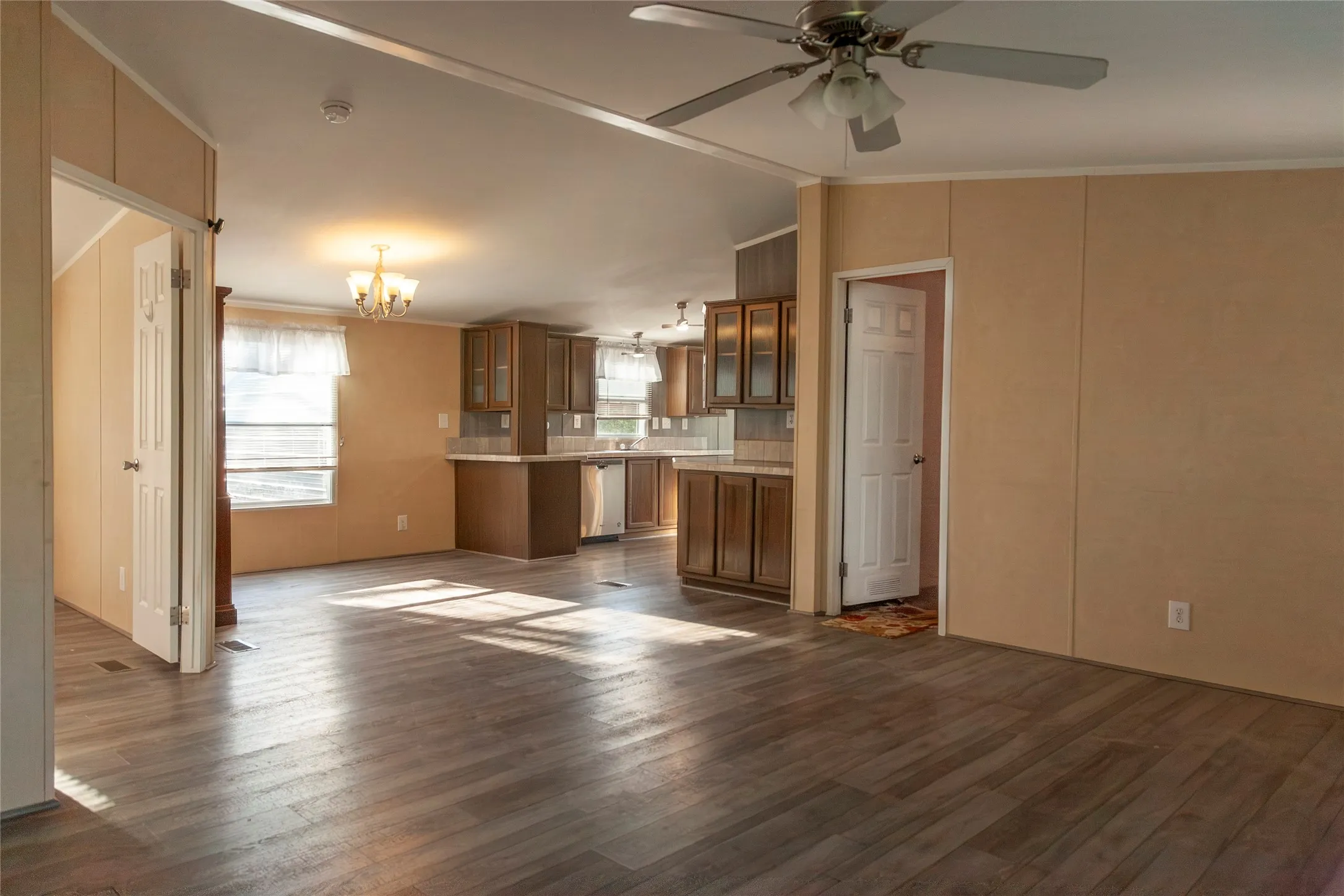 Spacious open-concept living area featuring wood-finish flooring, a ceiling fan, and recessed lighting