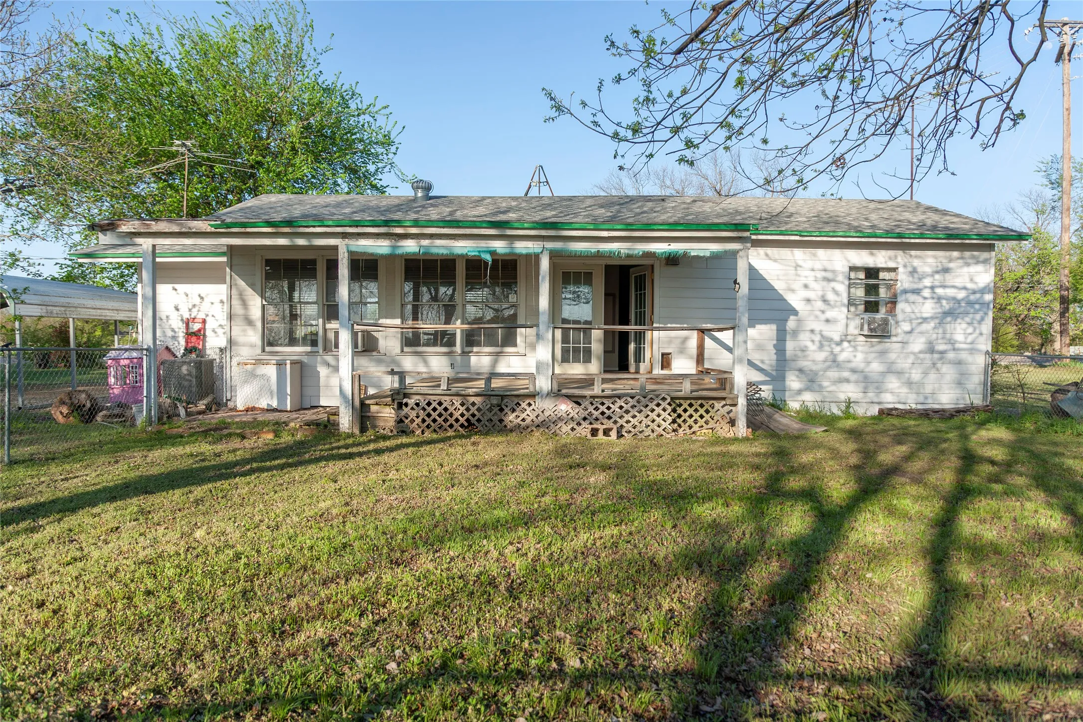 Single-story residence featuring a white exterior and a covered front porch with lattice detailing