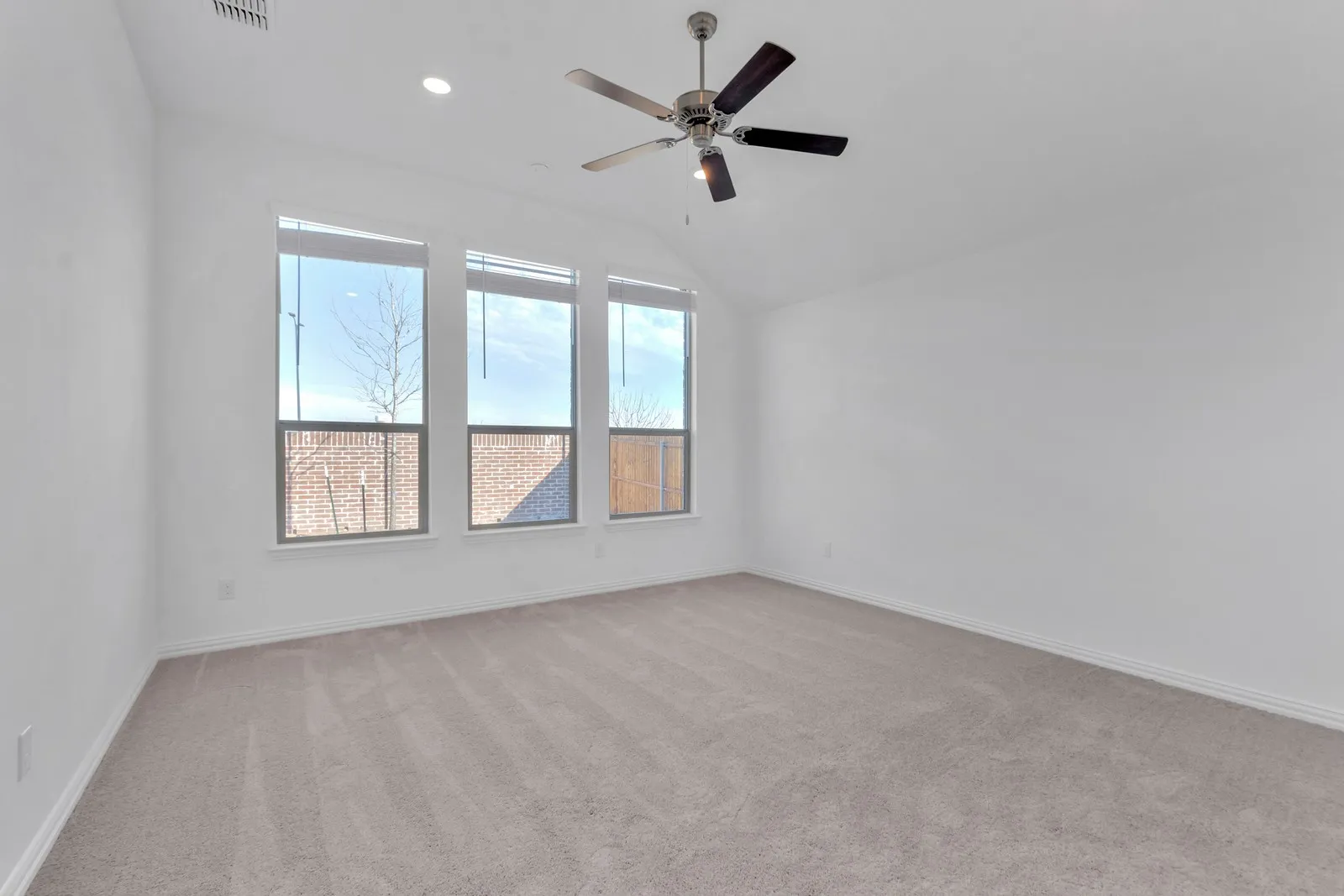 Carpeted spare room featuring ceiling fan, lofted ceiling, and recessed lighting