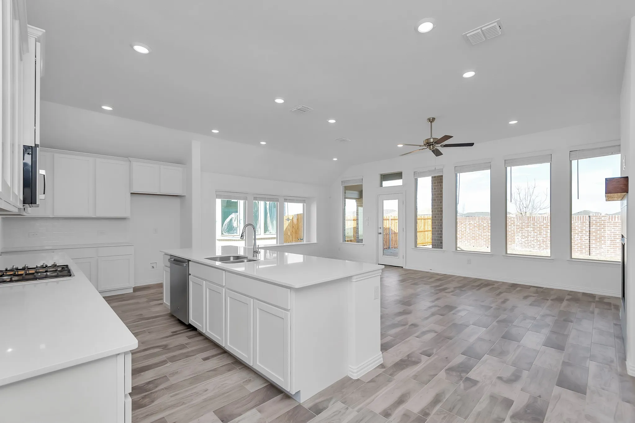 Kitchen featuring appliances with stainless steel finishes, a ceiling fan, recessed lighting, open floor plan, and white cabinets
