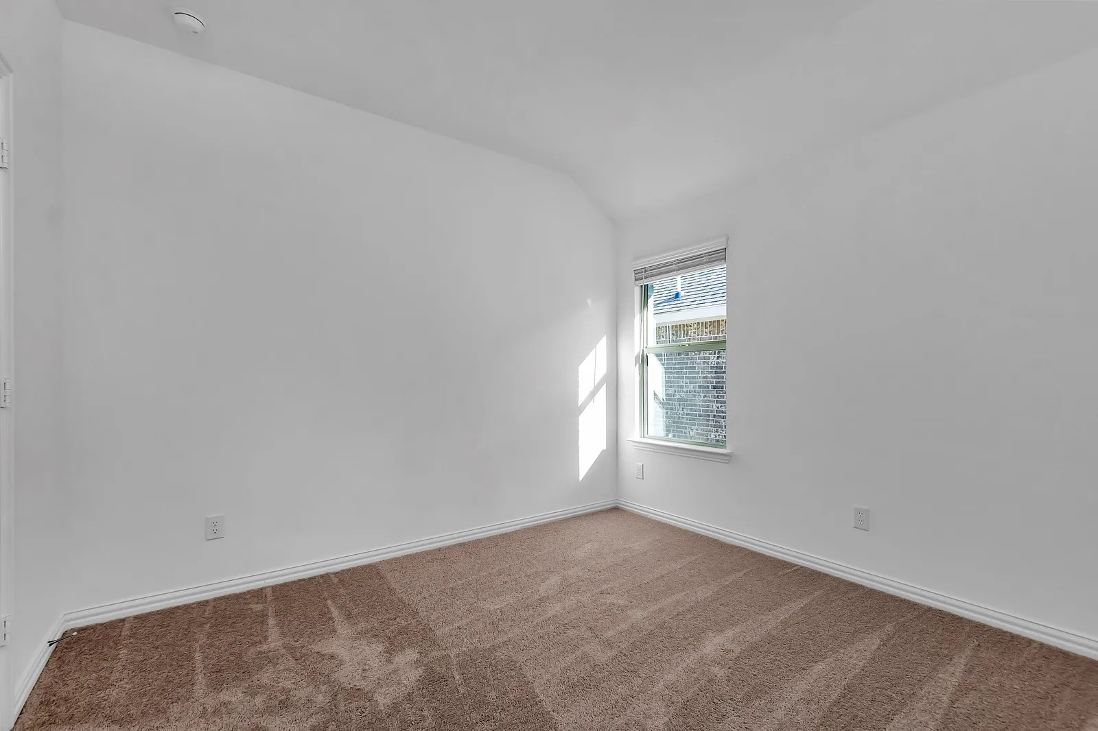 Unfurnished room featuring a smoke detector, vaulted ceiling, and carpet floors