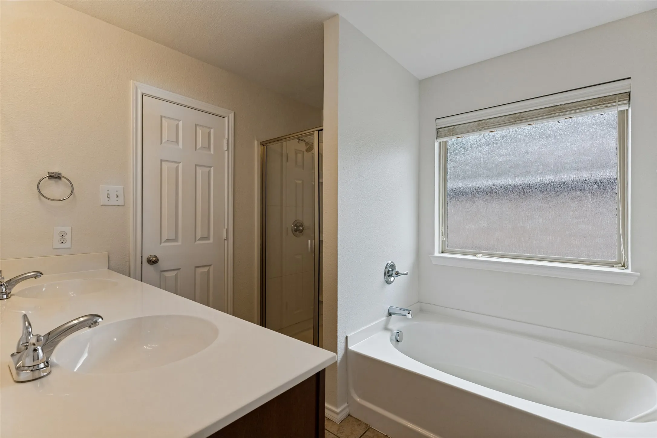 Master bathroom featuring dual vanity with white quartz countertop, chrome faucetry, and ample storage