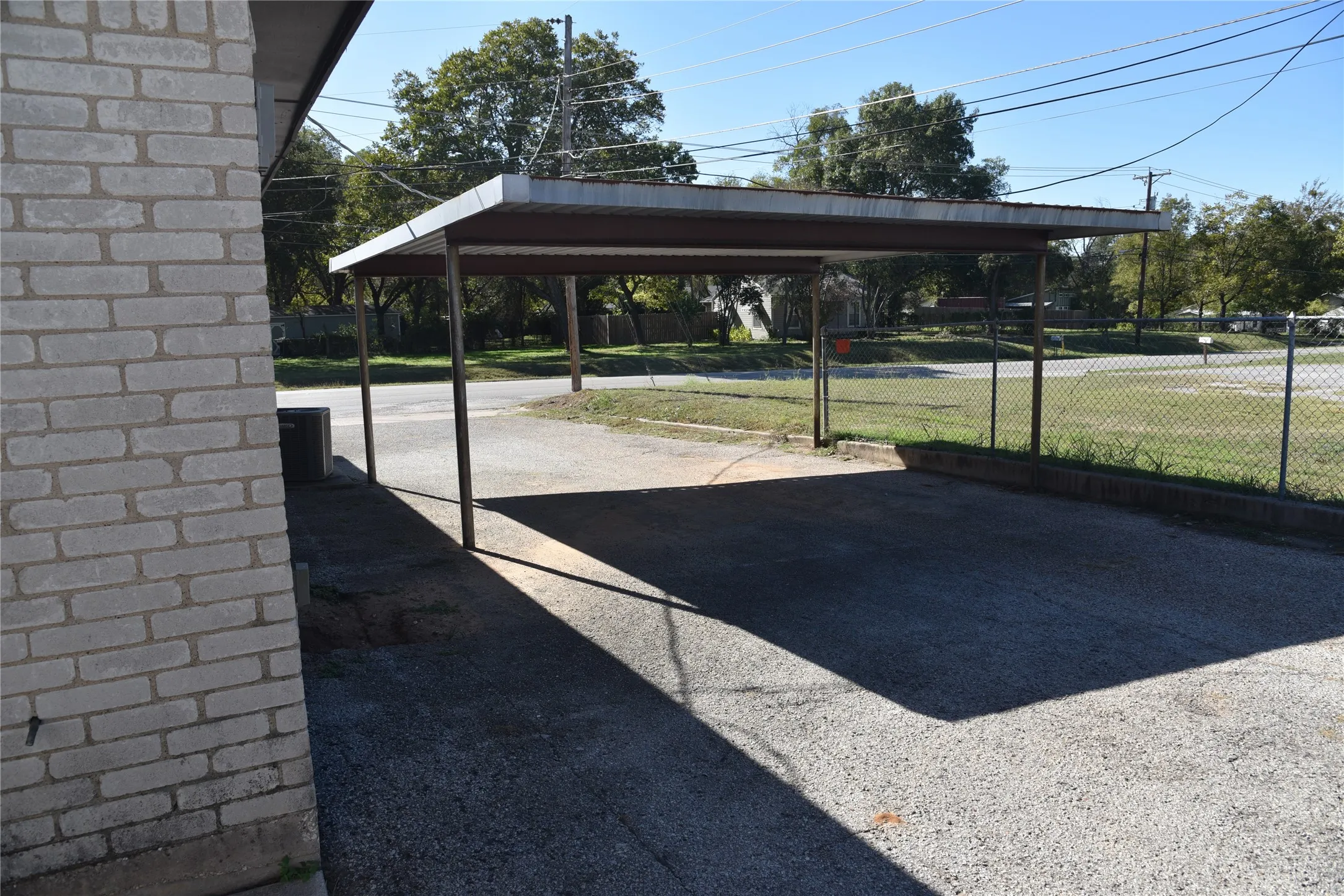 View of car parking featuring a designated carport and one uncovered spot