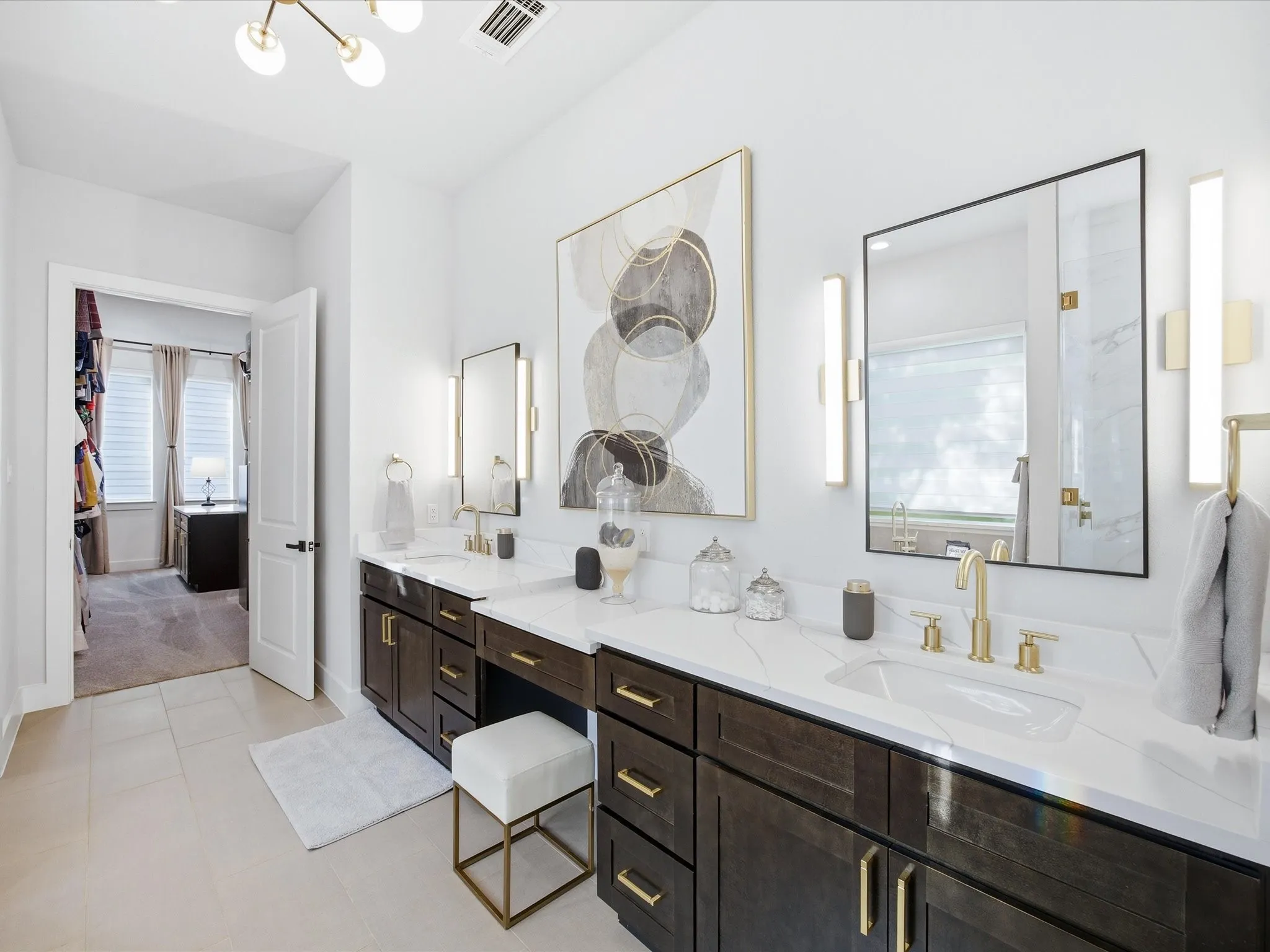 Bathroom featuring double vanity, plenty of natural light, hanging lights, and a marble finish shower
