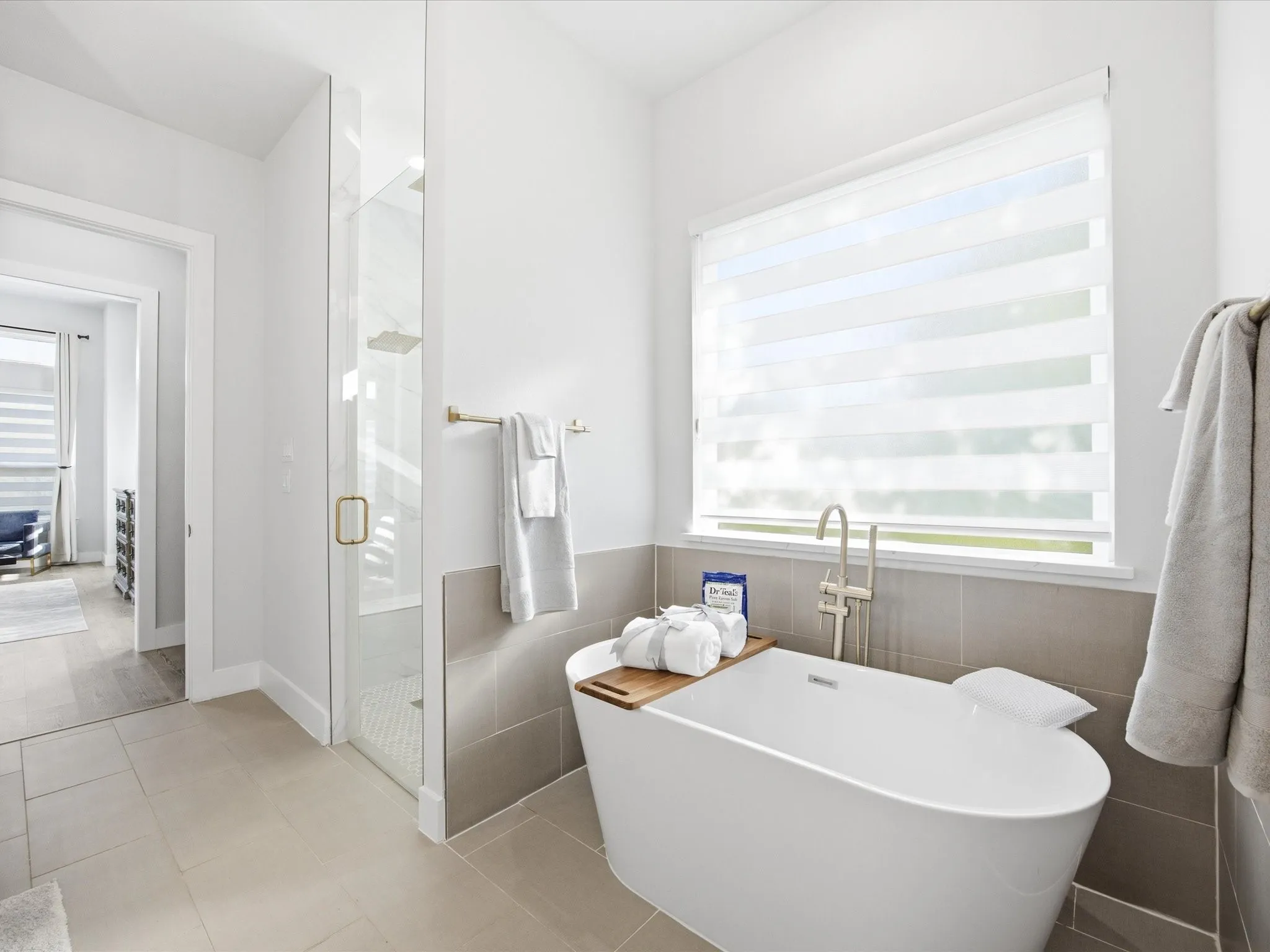 Full bathroom featuring a shower stall, a soaking tub, healthy amount of natural light, light tile patterned flooring, and tile walls