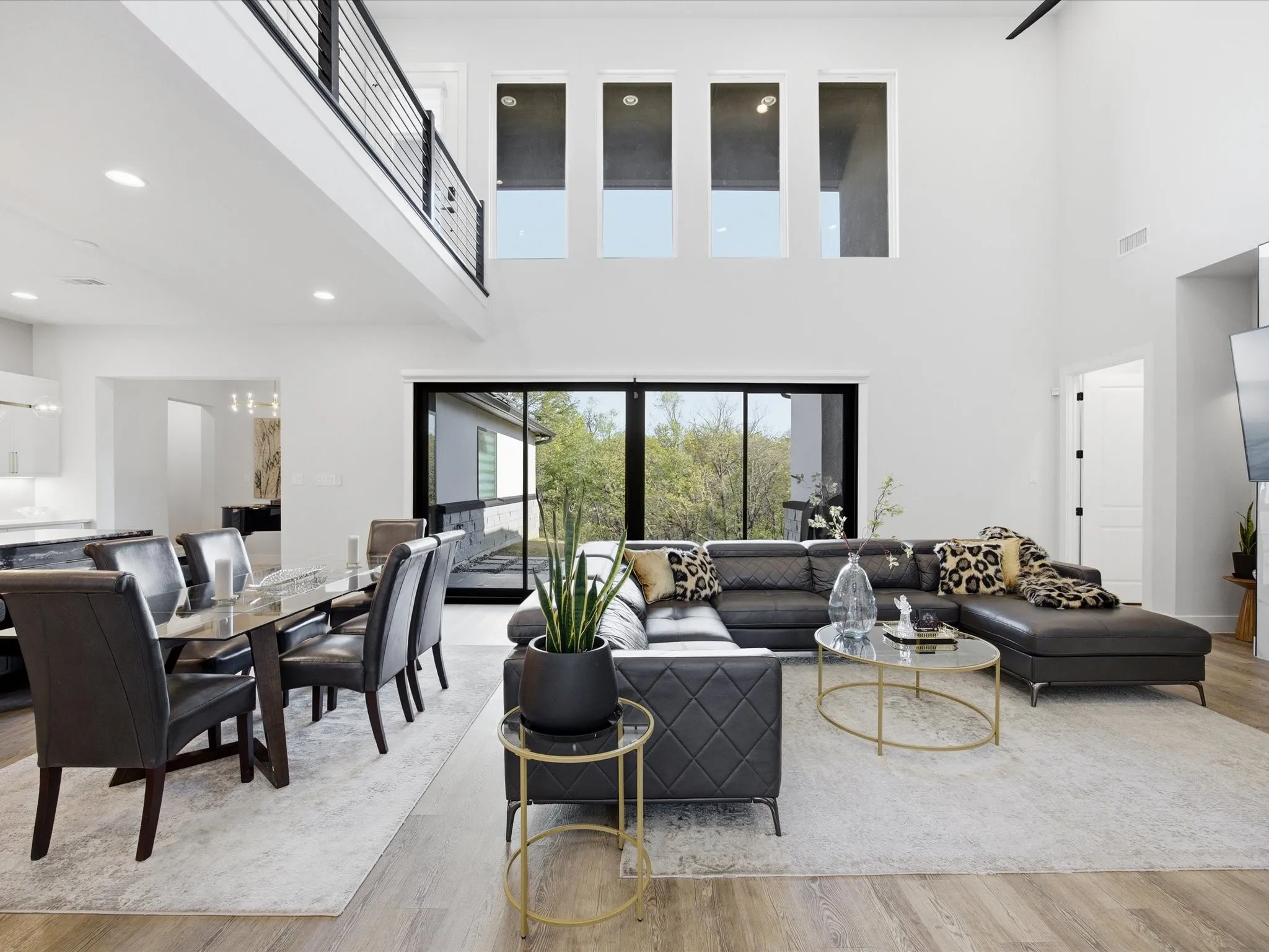 Living room featuring light wood-type flooring, a high ceiling, and recessed lighting