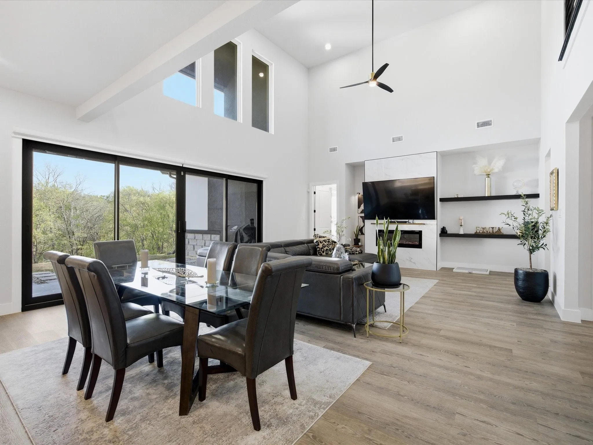 Dining area featuring light wood-style floors, a high ceiling, and ceiling fan