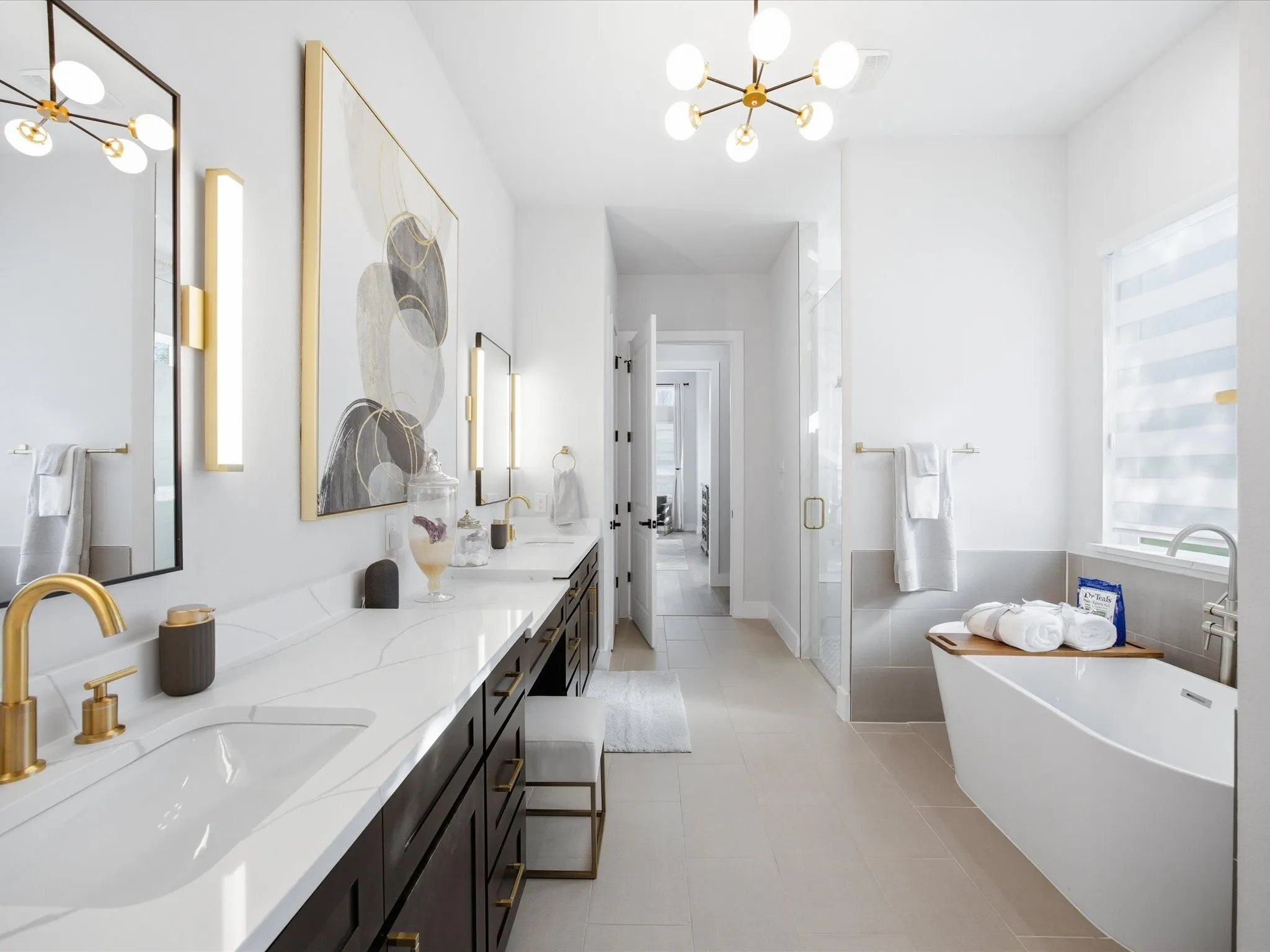 Bathroom featuring suspended lighting, a shower stall, a freestanding tub, and double vanity