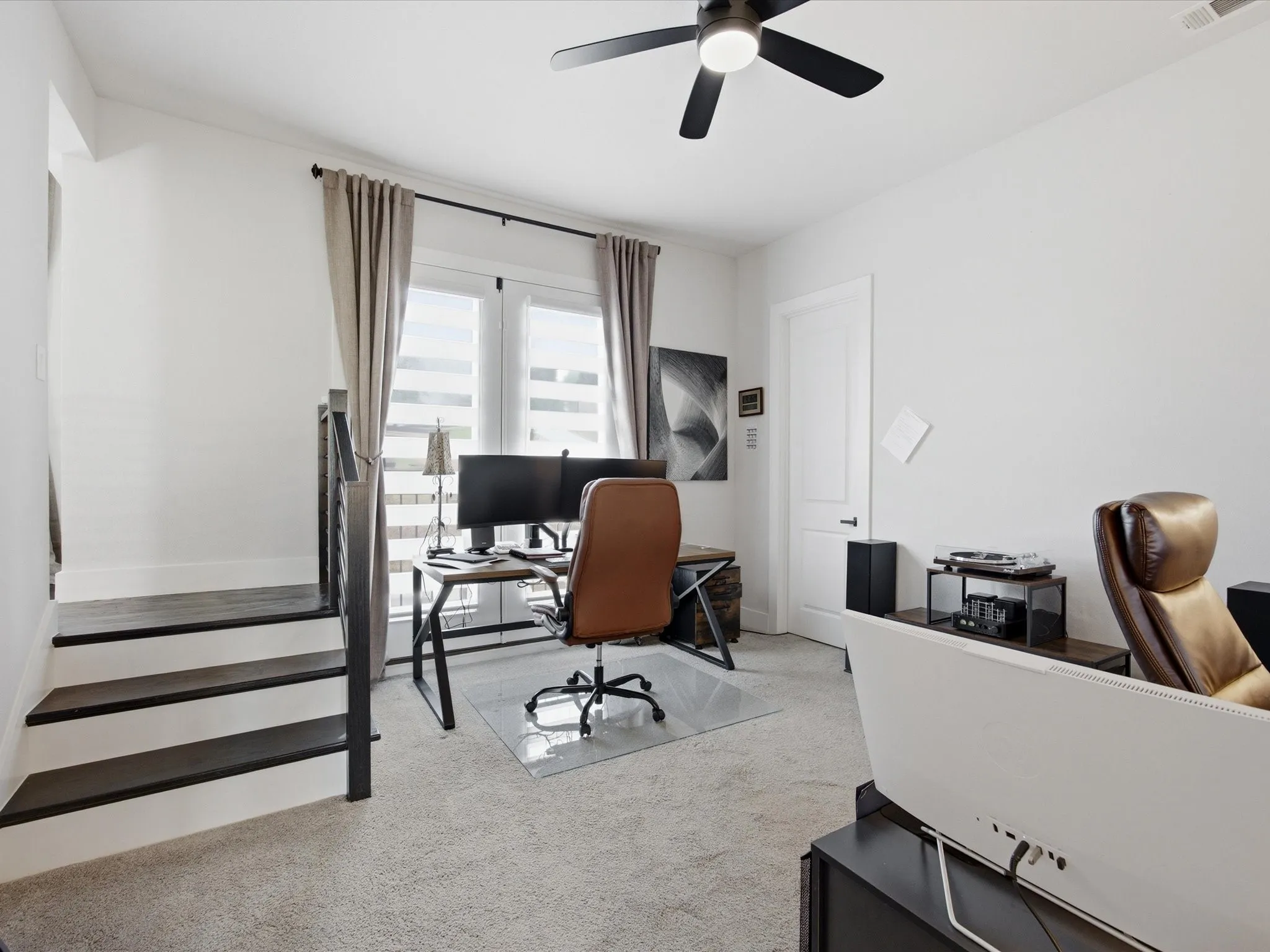 Home office featuring light colored carpet and ceiling fan