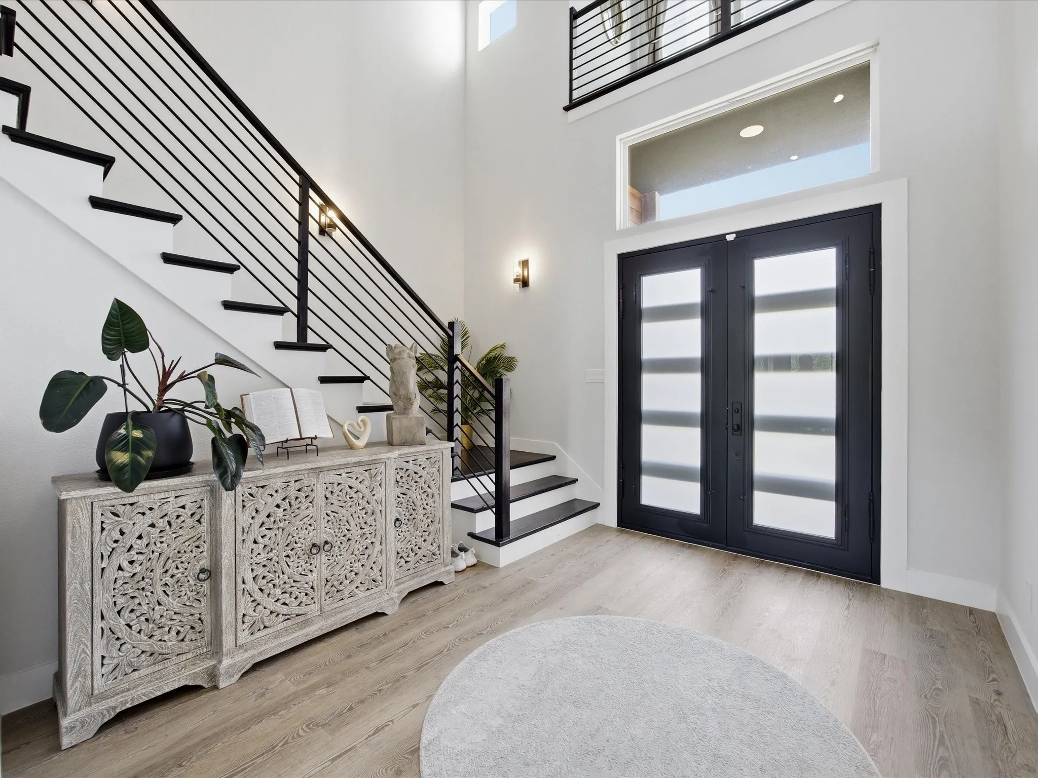 Entryway featuring a high ceiling, french doors, and light wood-style flooring
