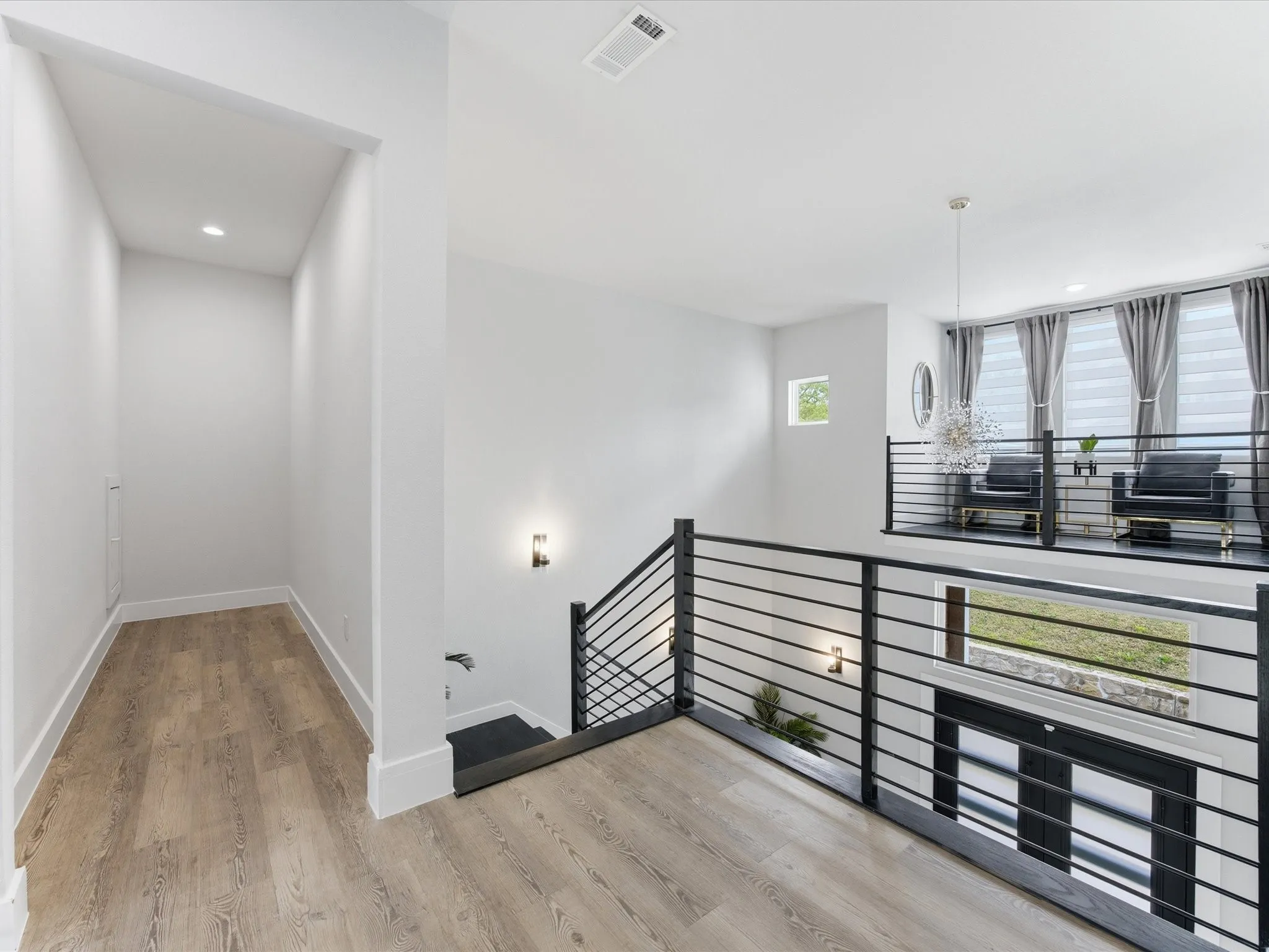 Stairway featuring wood finished floors and suspended lighting