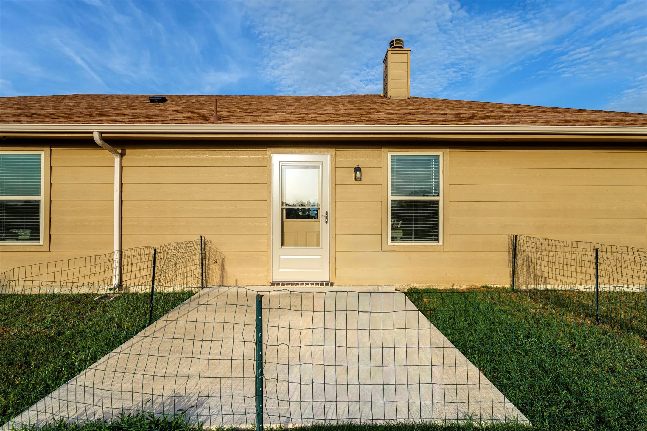Light brown siding with a brown shingle roof