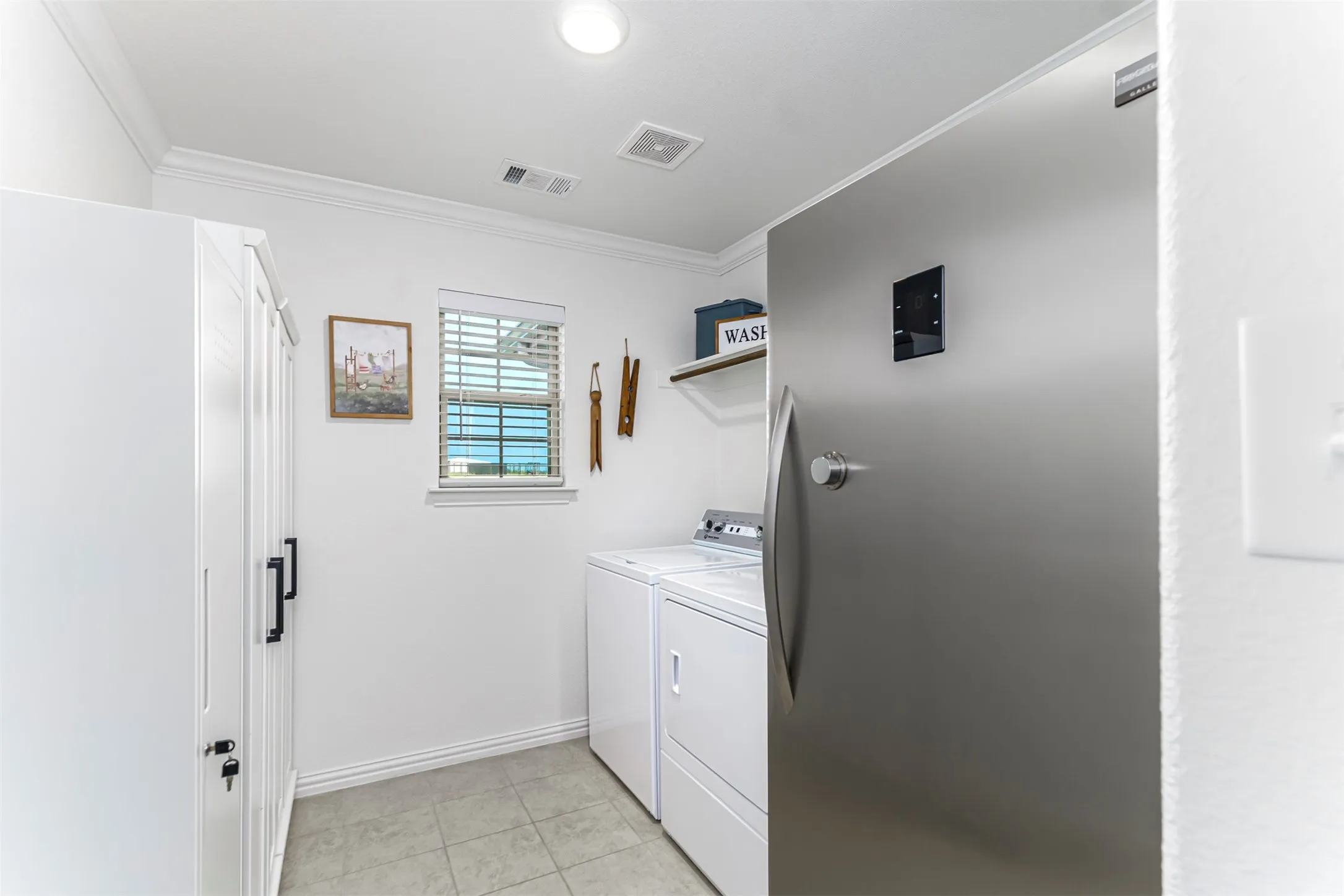 White utility room with crown molding, tiled flooring, and a single window with blinds