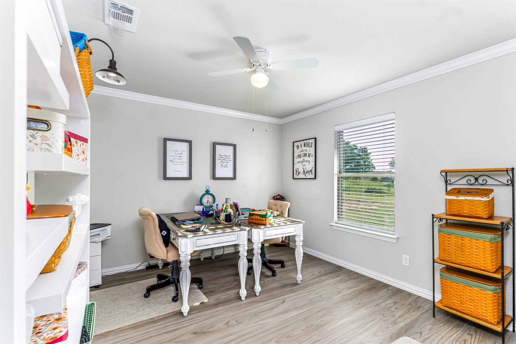 Wood-finish flooring, crown molding, and a ceiling fan