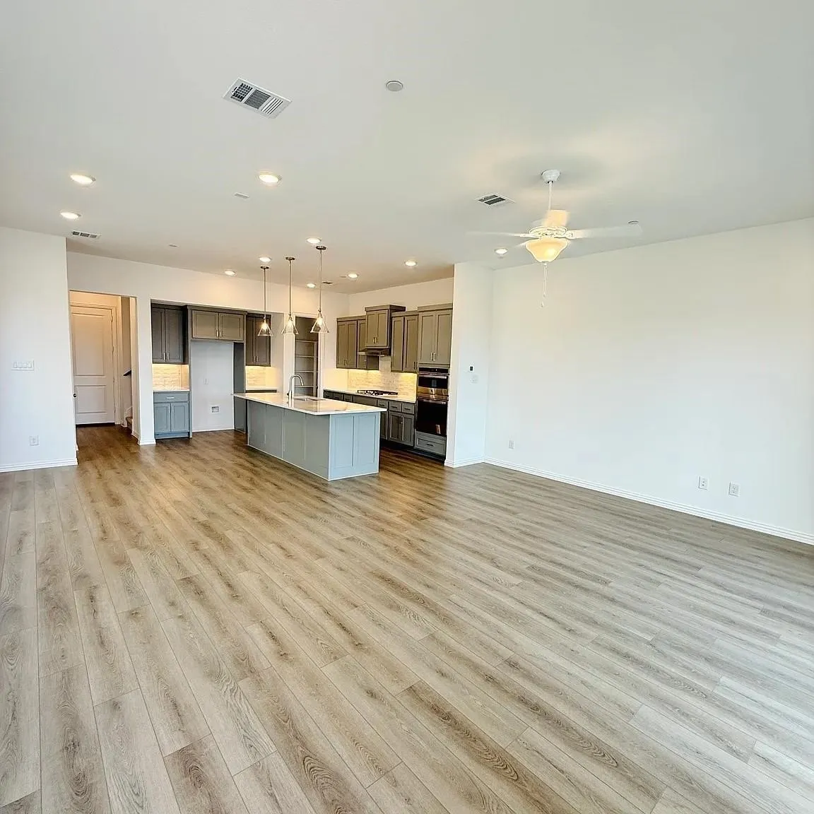 Open-concept living area featuring wood-finish flooring, recessed lighting, and a ceiling fan