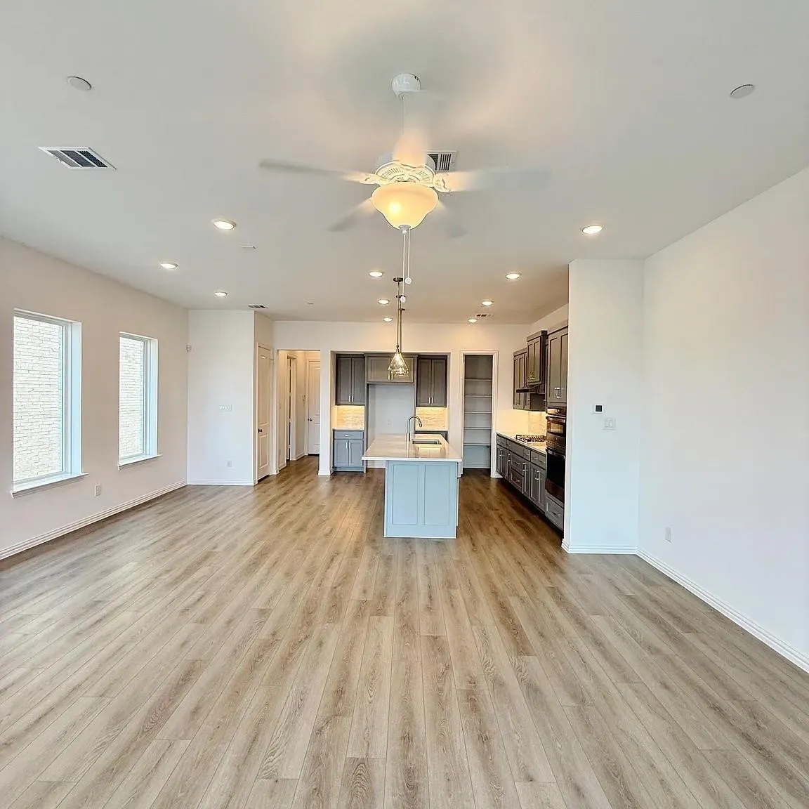 Open-concept living area featuring wood-finish flooring, recessed lighting, and a ceiling fan