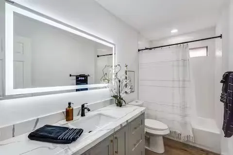 Vanity with a rectangular undermount sink, quartz-finish countertop, and matte black faucet