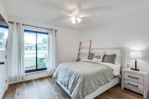 Wood-finish flooring, white walls, and a ceiling fan