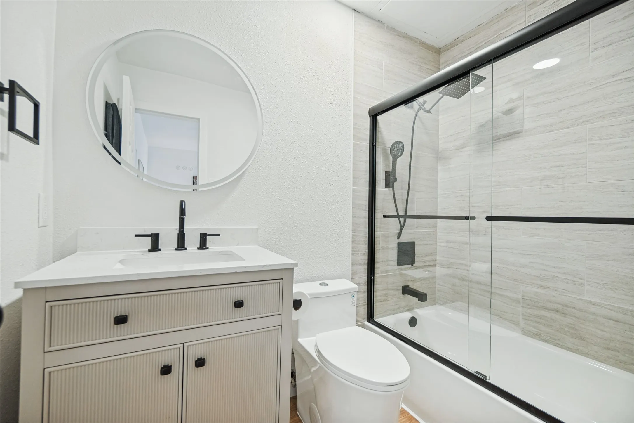 White vanity with fluted drawer and cabinet fronts, white countertop, and matte black fixtures