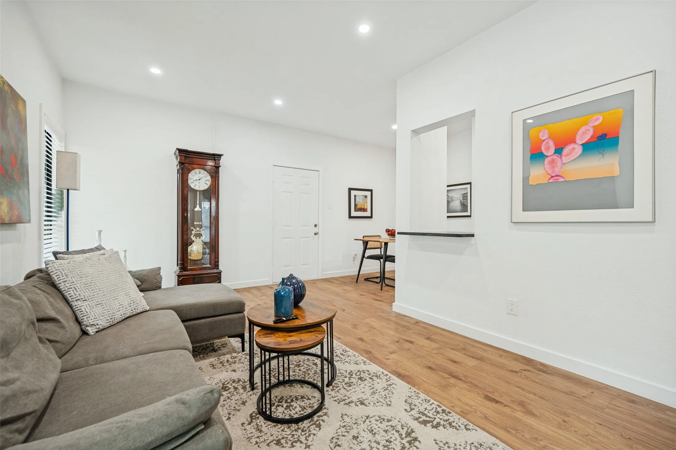 Recessed lighting illuminates the space, featuring wood-finish flooring and white walls