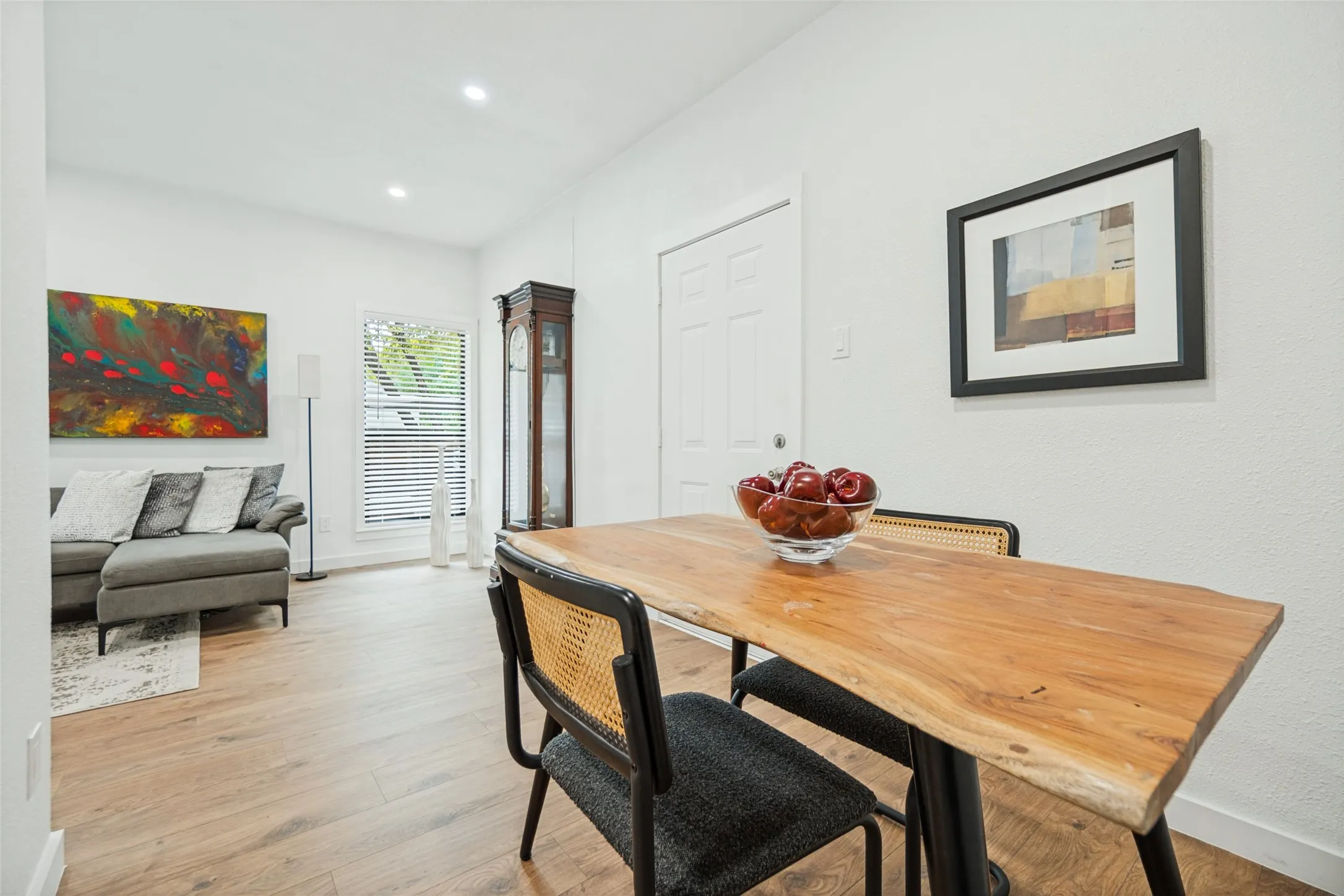 Recessed lighting, wood-finish flooring, white paneled door, window with blinds, white wall finishes