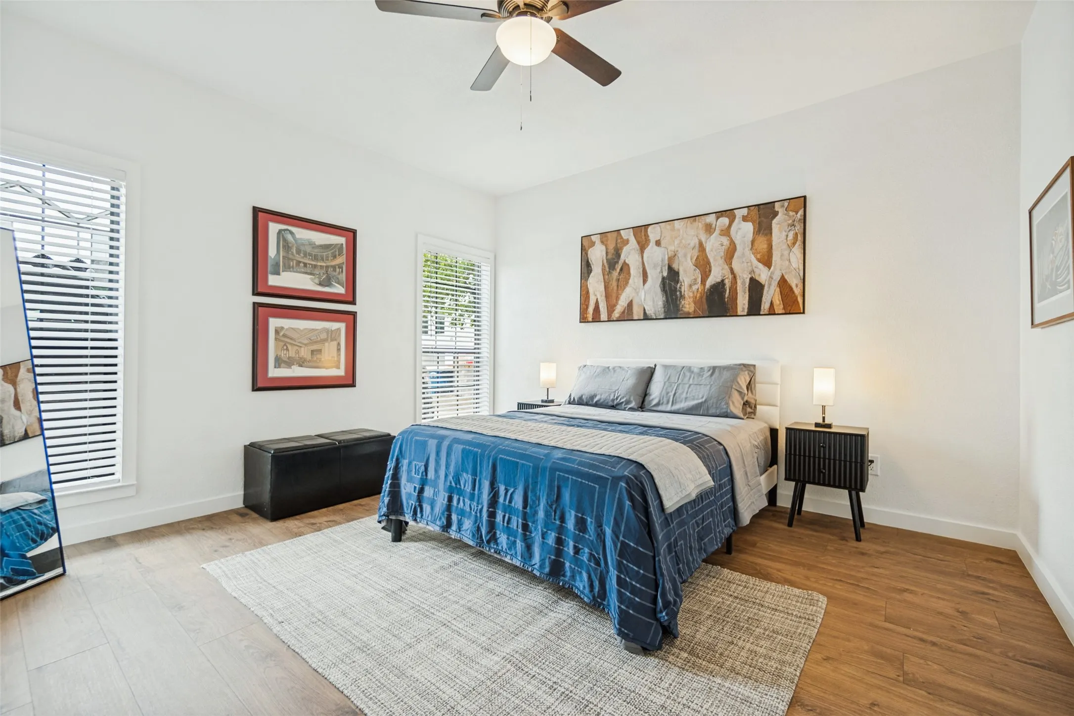Hardwood-finish flooring, white walls, and a ceiling fan with integrated lighting
