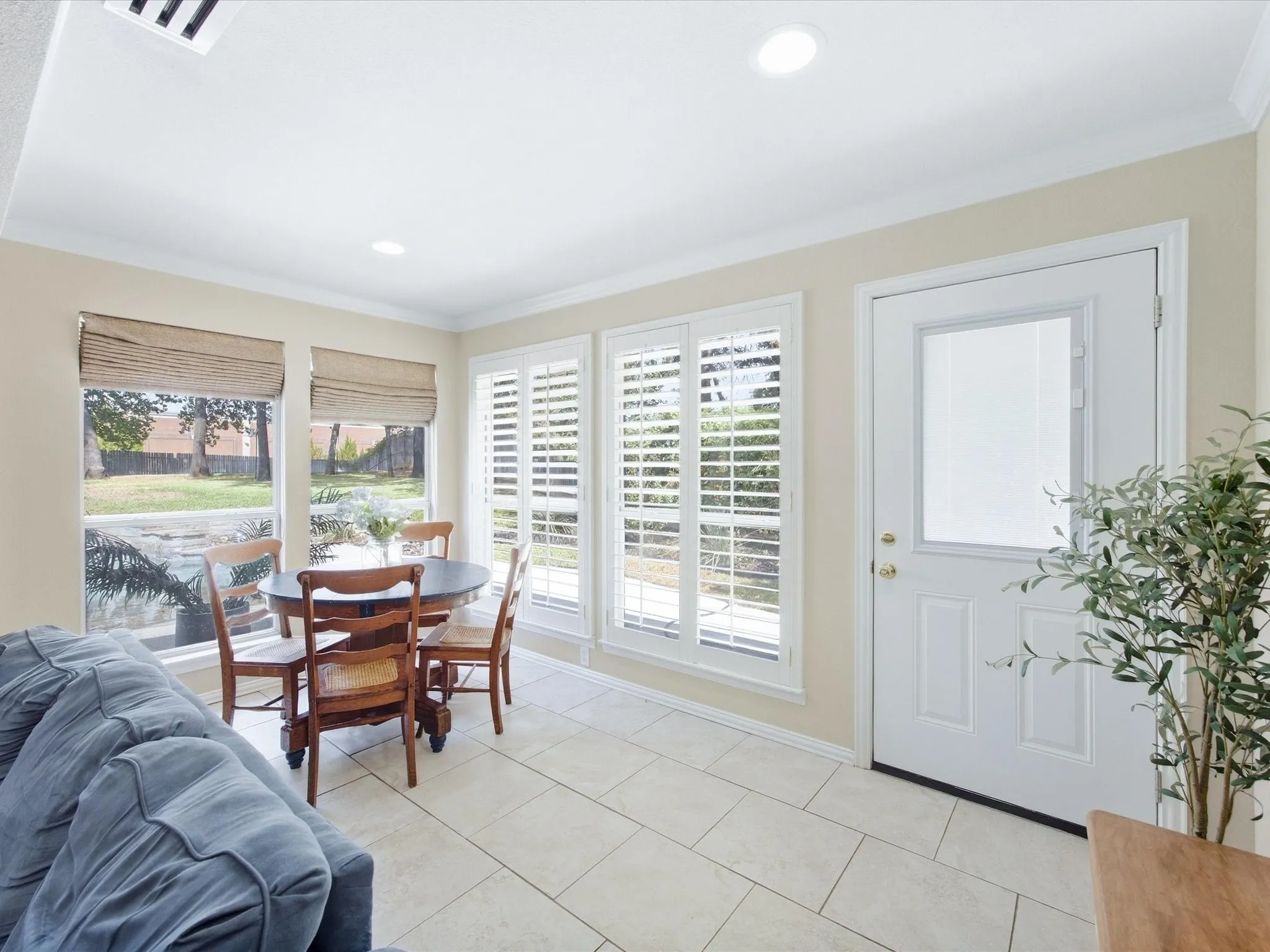 Recessed lighting, crown molding, multiple windows with blinds, tiled flooring, and a white paneled door with a glass insert