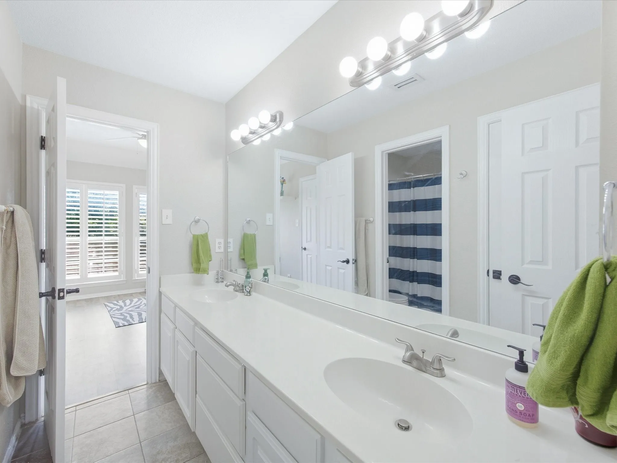 Dual vanity with white undermount sinks, chrome faucets, and white cabinetry