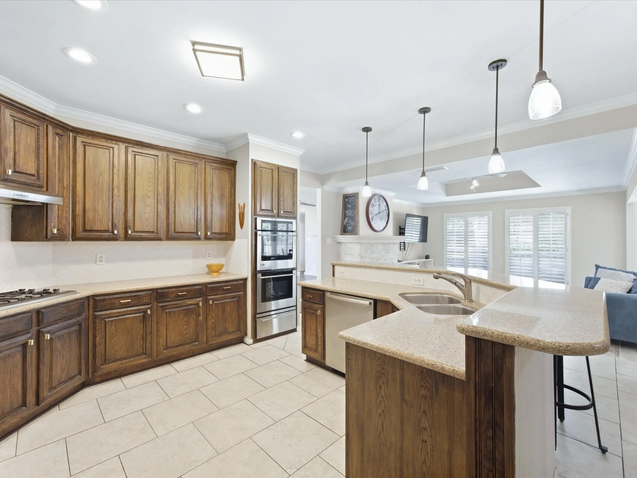 Spacious kitchen featuring warm wood cabinetry, stainless steel appliances, and dual islands with granite countertops