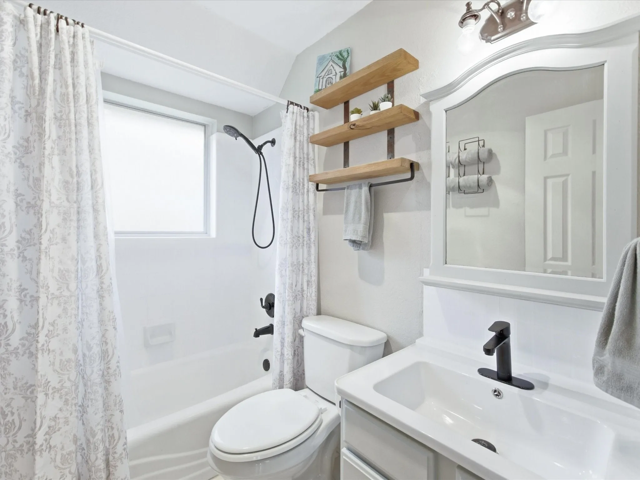 White vanity with integrated sink and matte black faucet