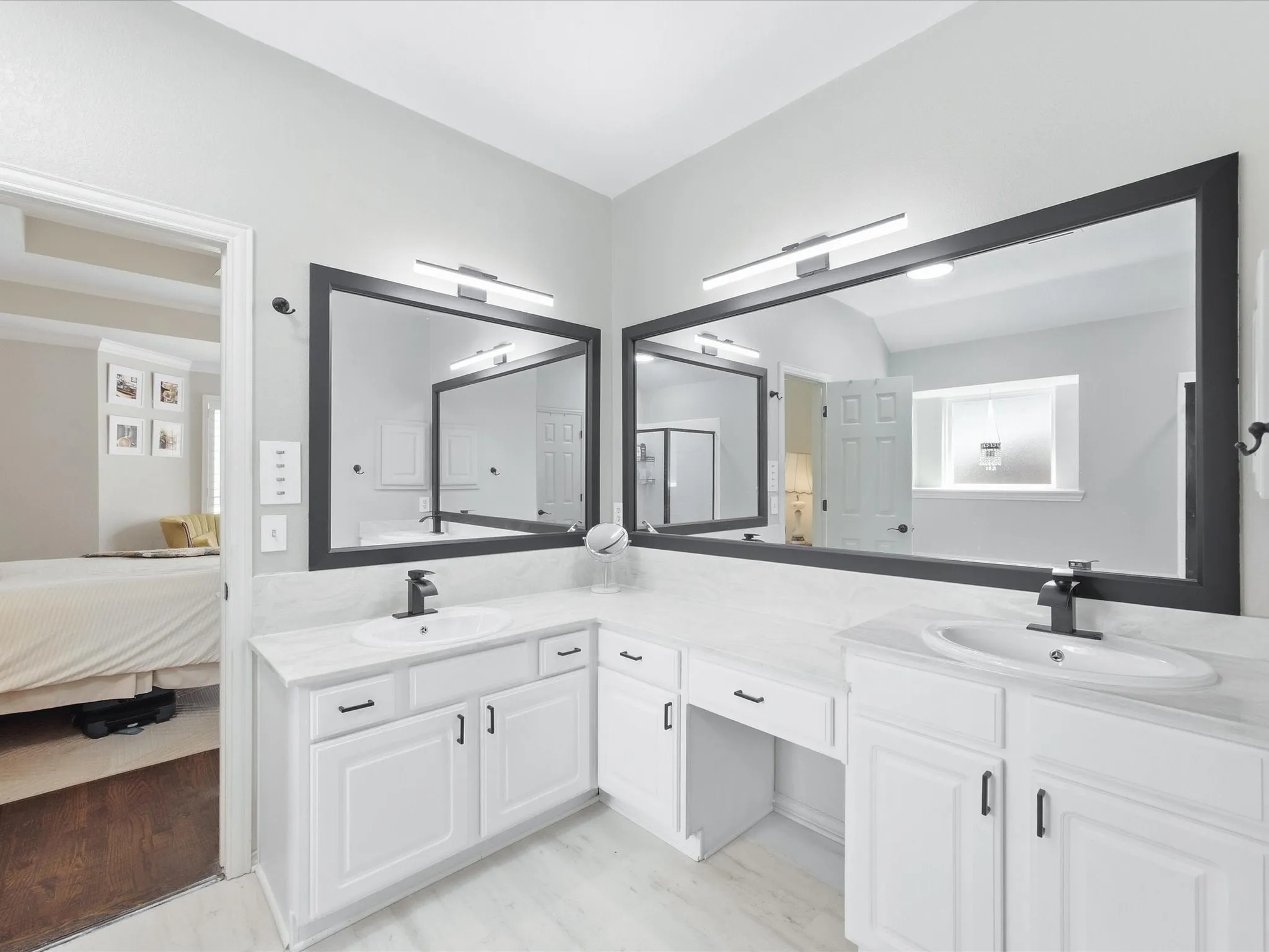 Dual vanity with white cabinetry, integrated sinks, white countertops, and matte black fixtures