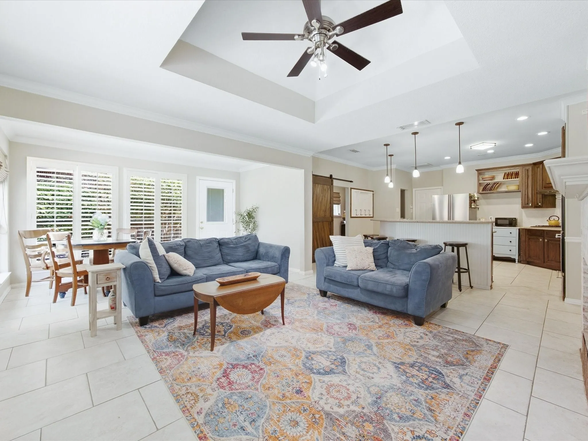 Open-concept living space featuring coffered ceiling with ceiling fan, recessed lighting, and skylights