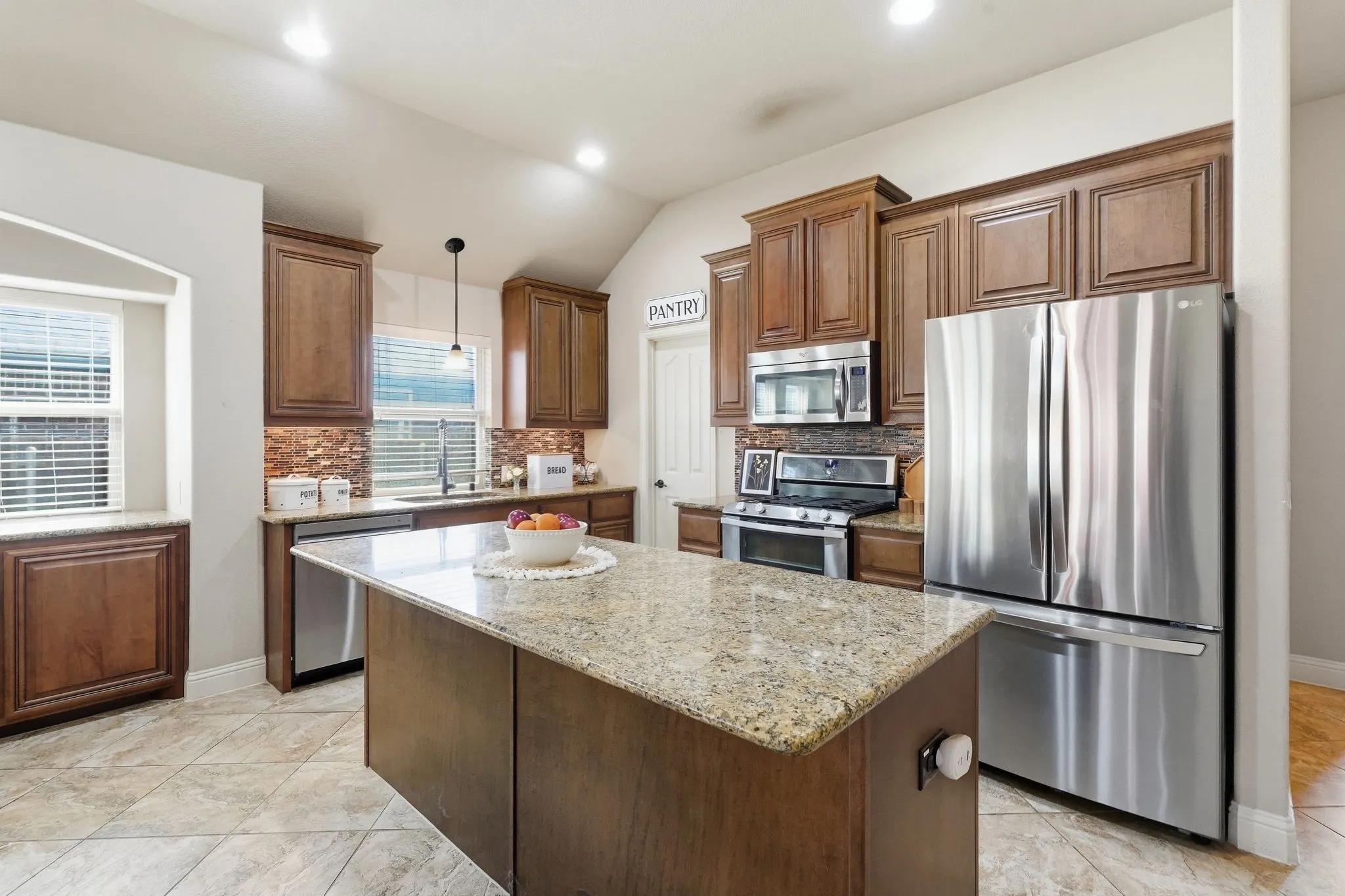 Kitchen featuring gas cooking, center island with granite countertops