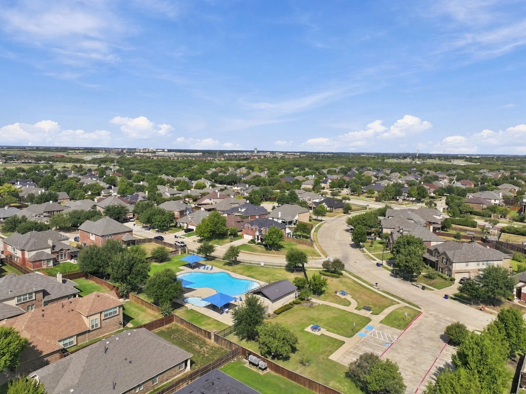 Community pool with lounge areas and adjacent green space