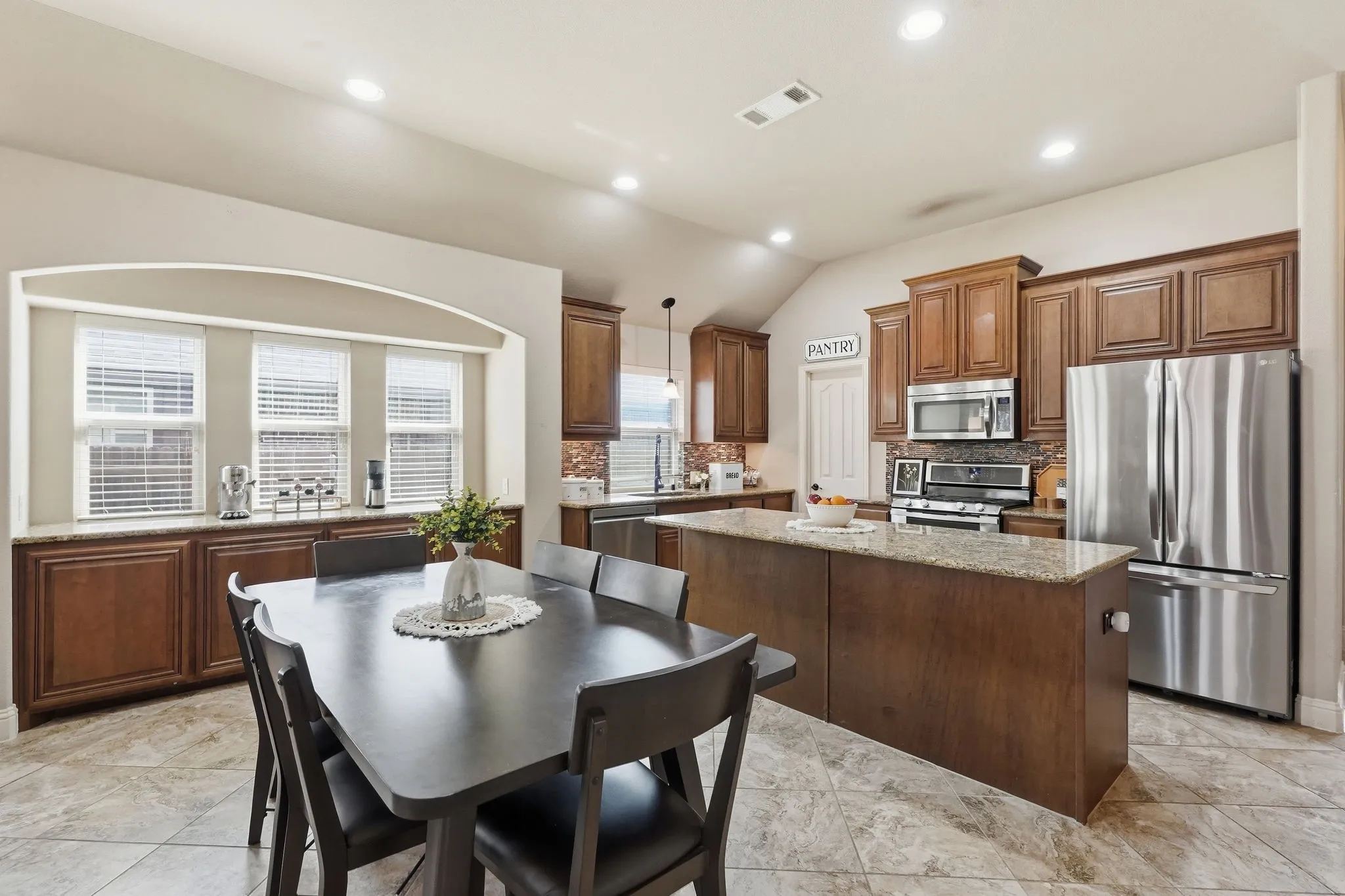 Bultler's pantry with granite countertop and abundant cabinets