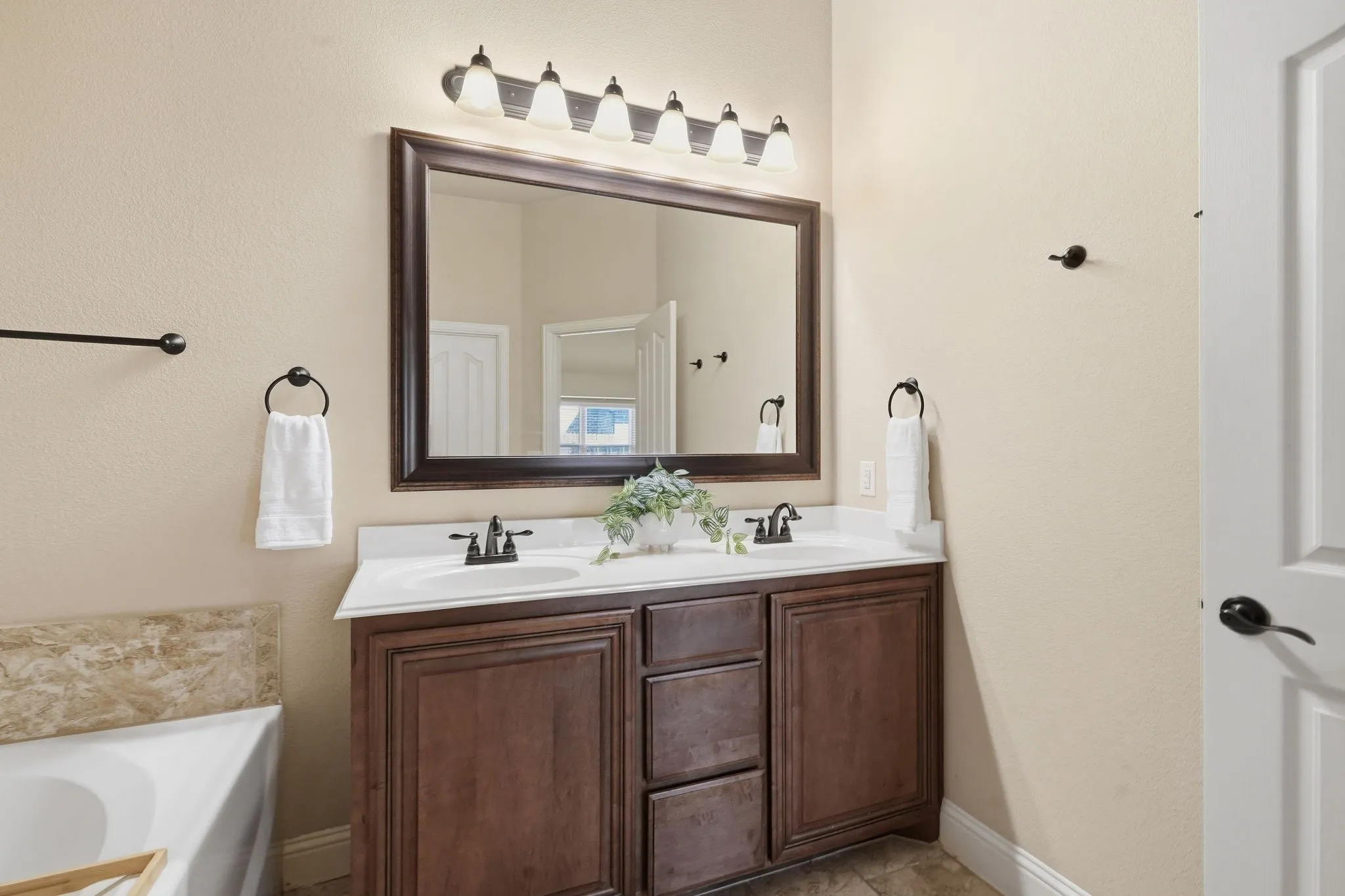 Dual vanity with dark wood-finish cabinetry, white countertop, and integrated sinks