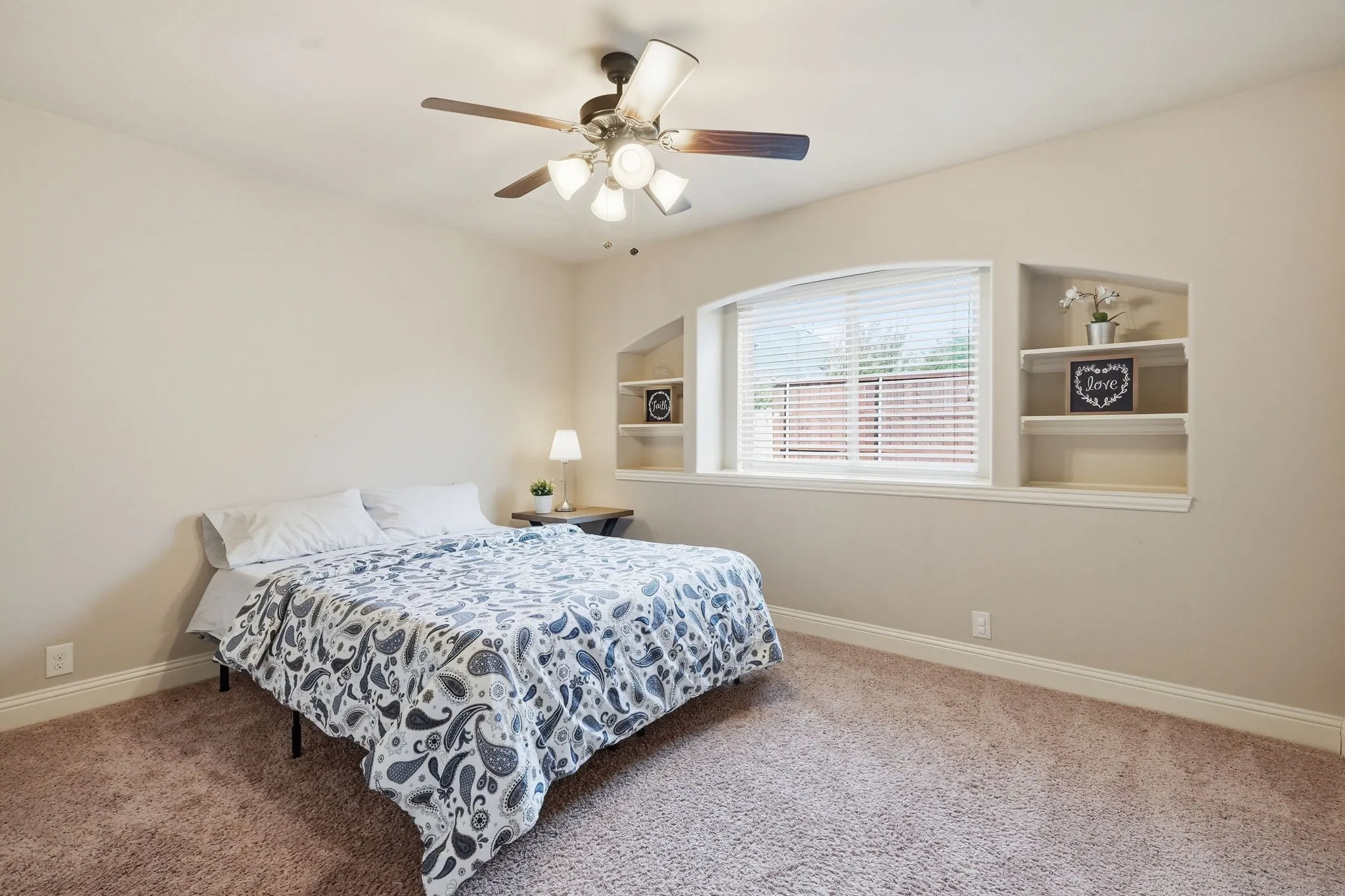Main level bedroom with built-in shelving and large walk-in closet