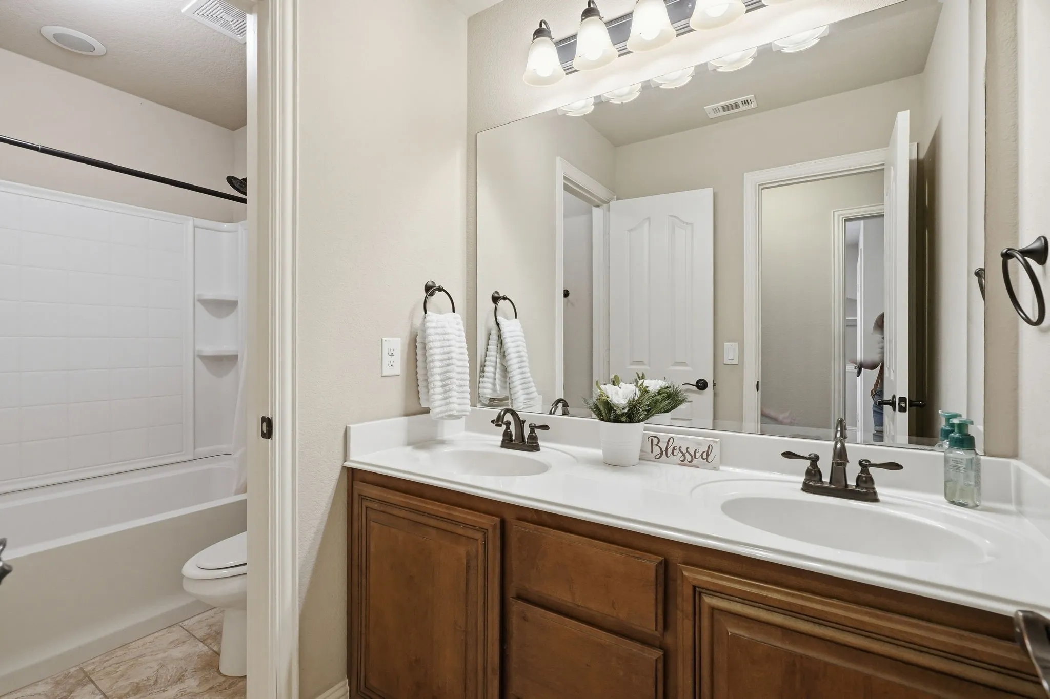 Spacious full bathroom on main level with dual vanity & additional door for private bathing