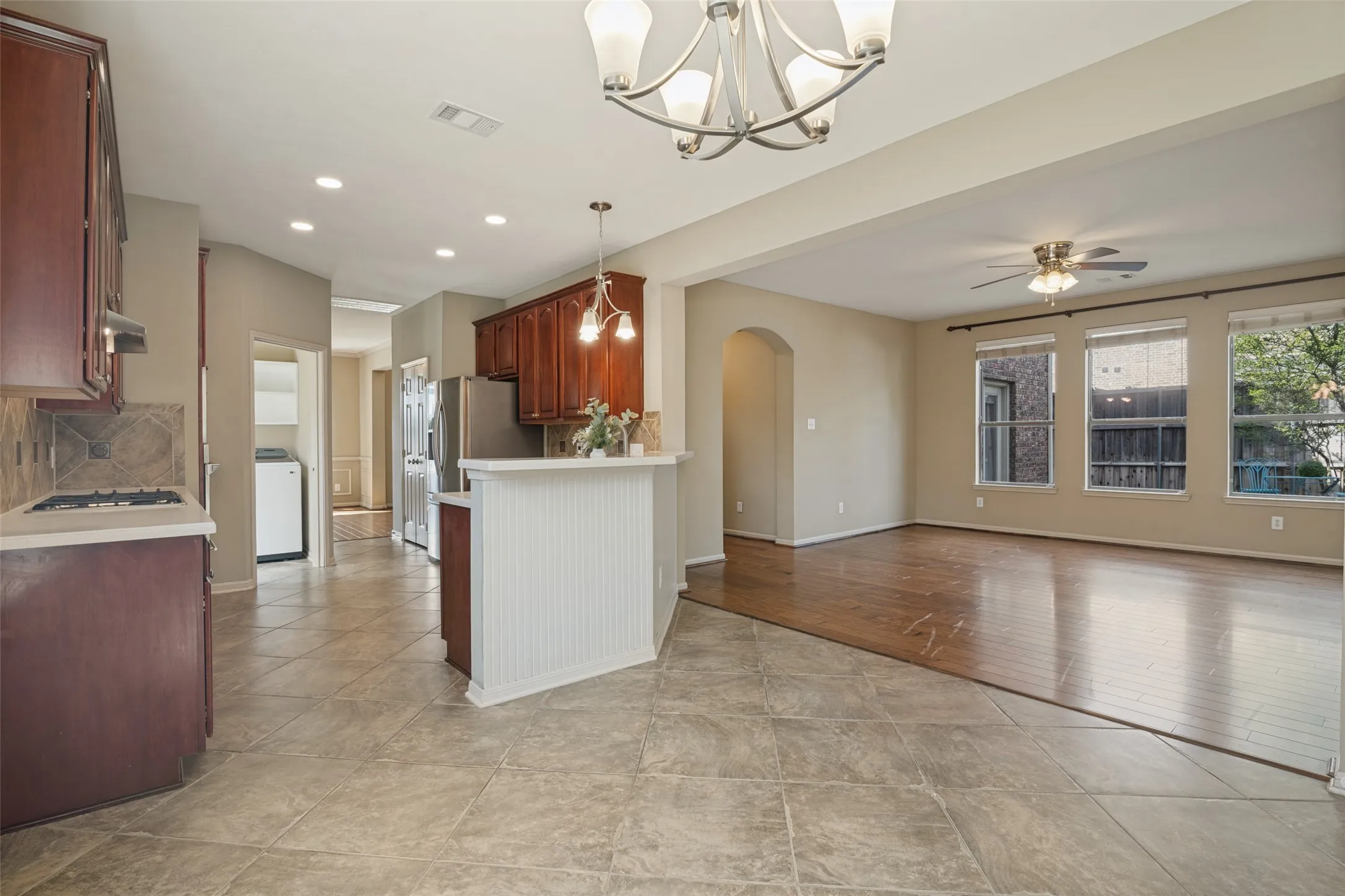 Kitchen featuring wood cabinetry, tile backsplash, and a breakfast bar from the eat in kitchen