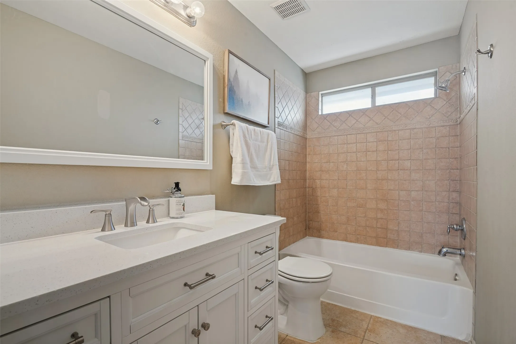 secondary bathroom #2 is just off the gameroom and has White vanity with a light-colored countertop and a rectangular sink and linen closet