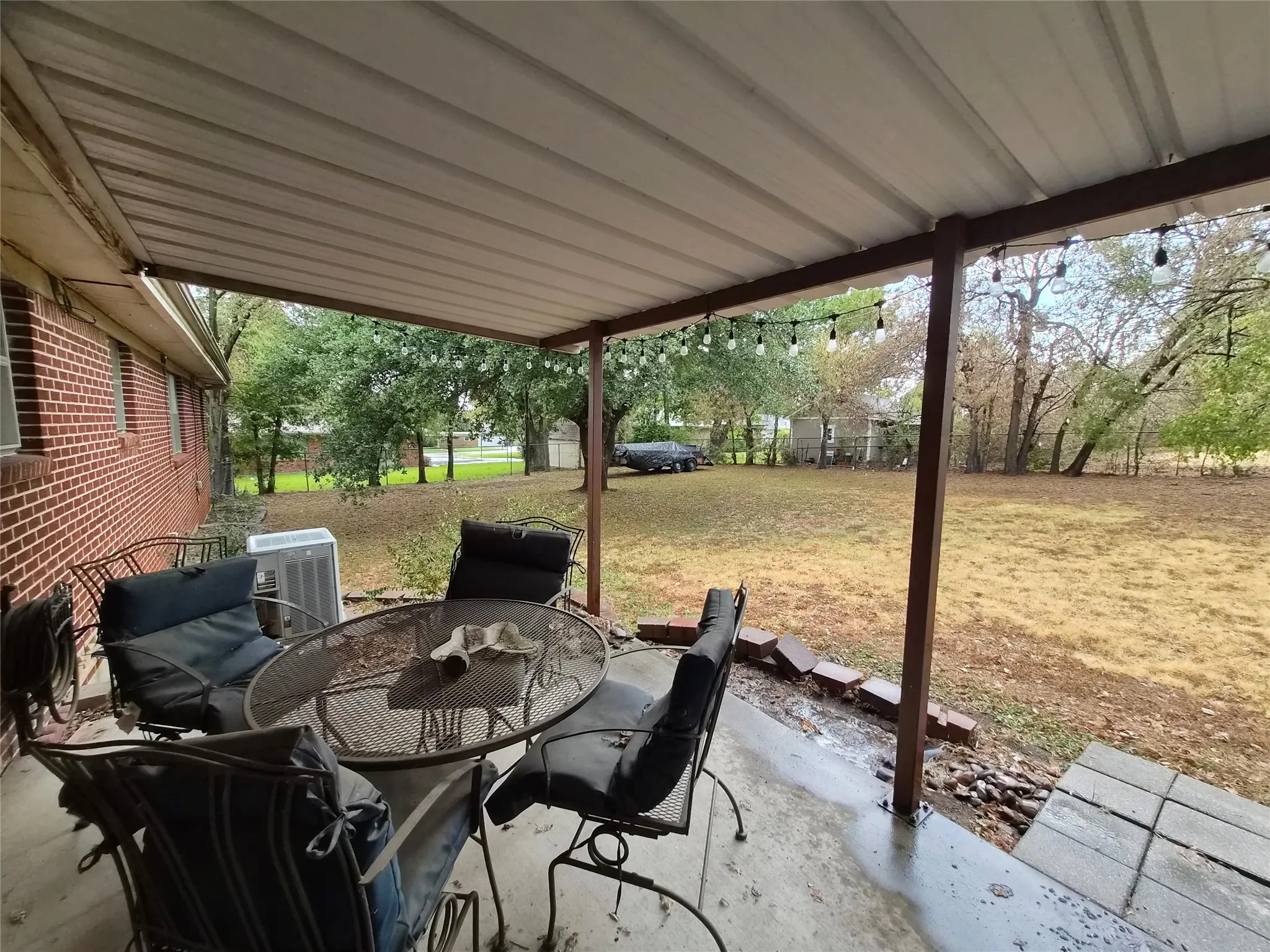 Covered patio in fenced backyard.