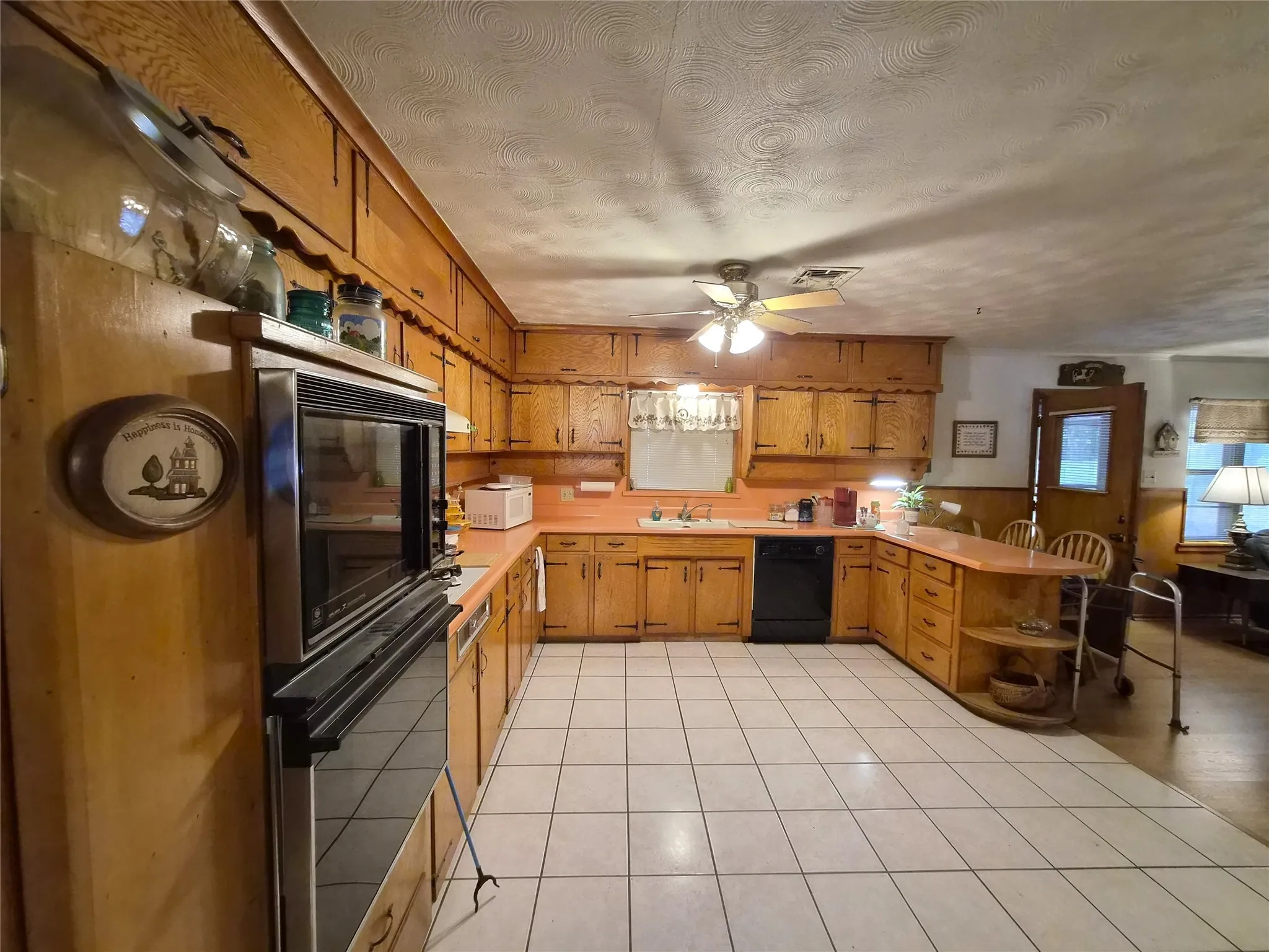 Plenty of cabinet space in this country kitchen with tile flooring.