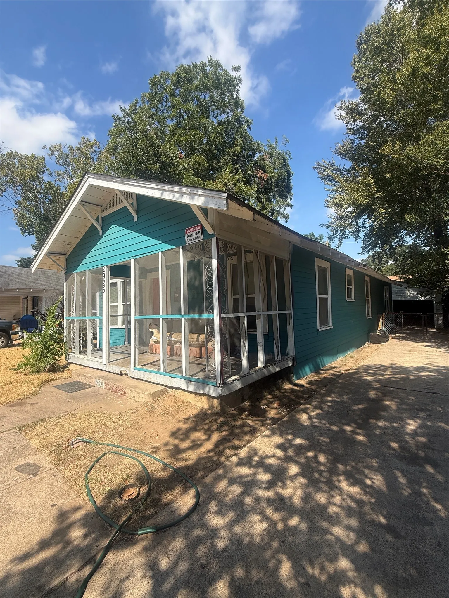 Exterior with teal horizontal siding, white trim, and a screened porch