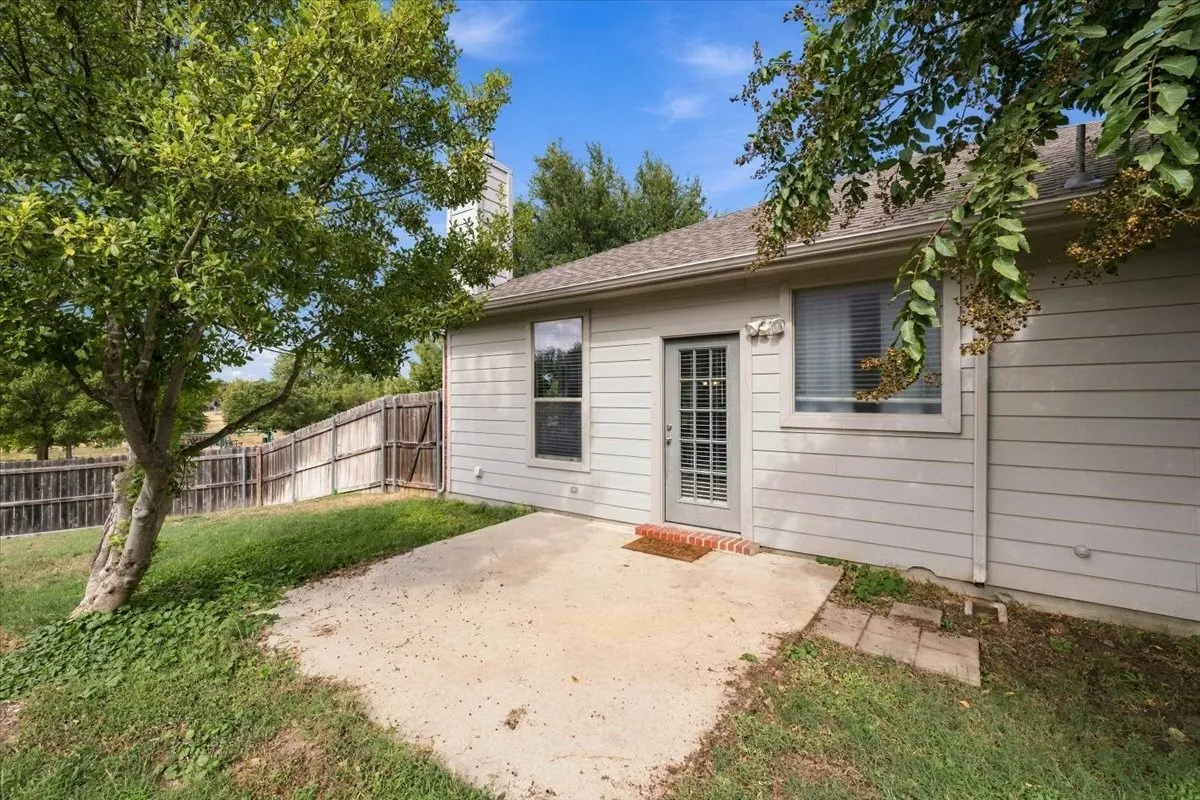 Rear exterior with horizontal siding, a glass-paned door, and a concrete patio