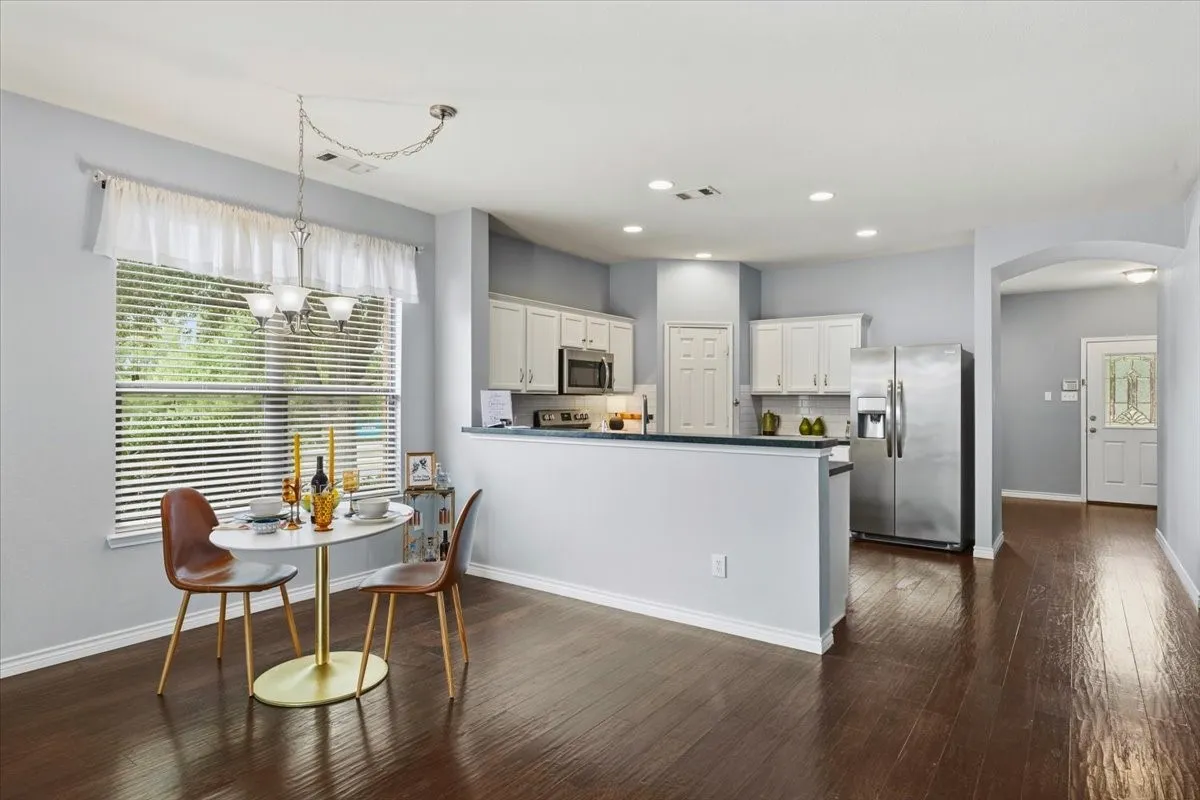 Kitchen with white cabinetry, stainless steel appliances, and a dark countertop