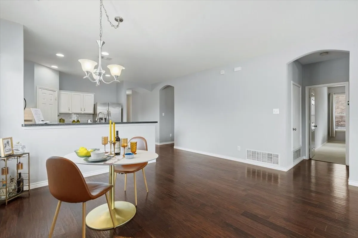 Wood-finish flooring throughout, with an arched doorway and recessed lighting